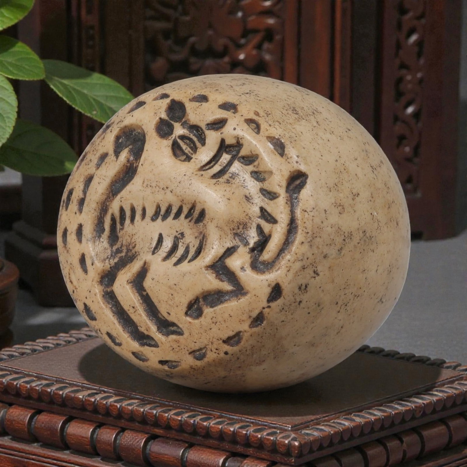 Ancient Near Eastern Steatite Zoomorphic Stamp Seal, 78YD: This ancient stamp seal is carved from weathered steatite, with a domed, spherical form and a central perforation for suspension. The flat face bears a deeply engraved intaglio depicting a stylized zo