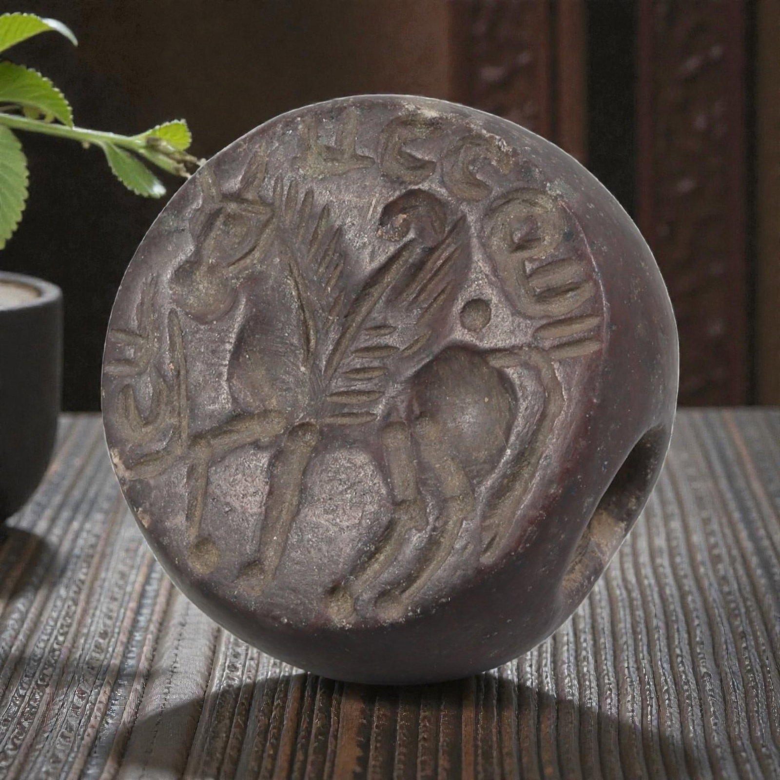 Ancient Sasanian Jasper Zoomorphic Stamp Seal, 79YD: This ancient stamp seal is carved from dark reddish-brown jasper, with a domed, lenticular form and central perforation for suspension. The flat face bears a deeply engraved intaglio depicting a winge