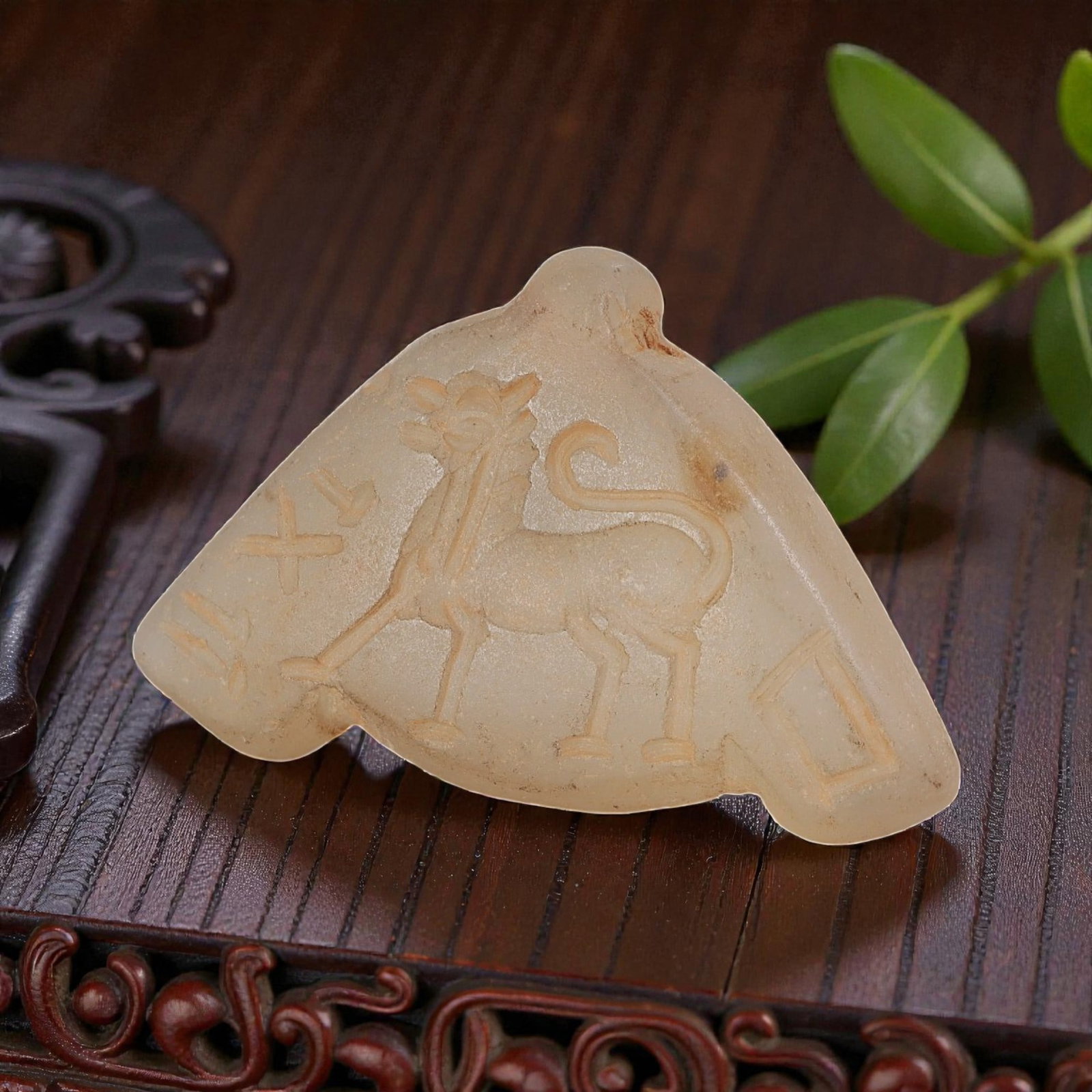 Ancient Sasanian Chalcedony Amulet Pendant, 53YD: This ancient amulet pendant is carved from translucent pale chalcedony, with a fan-shaped form and suspension lug at the top. The face features a deeply engraved intaglio depicting a stylized walking 