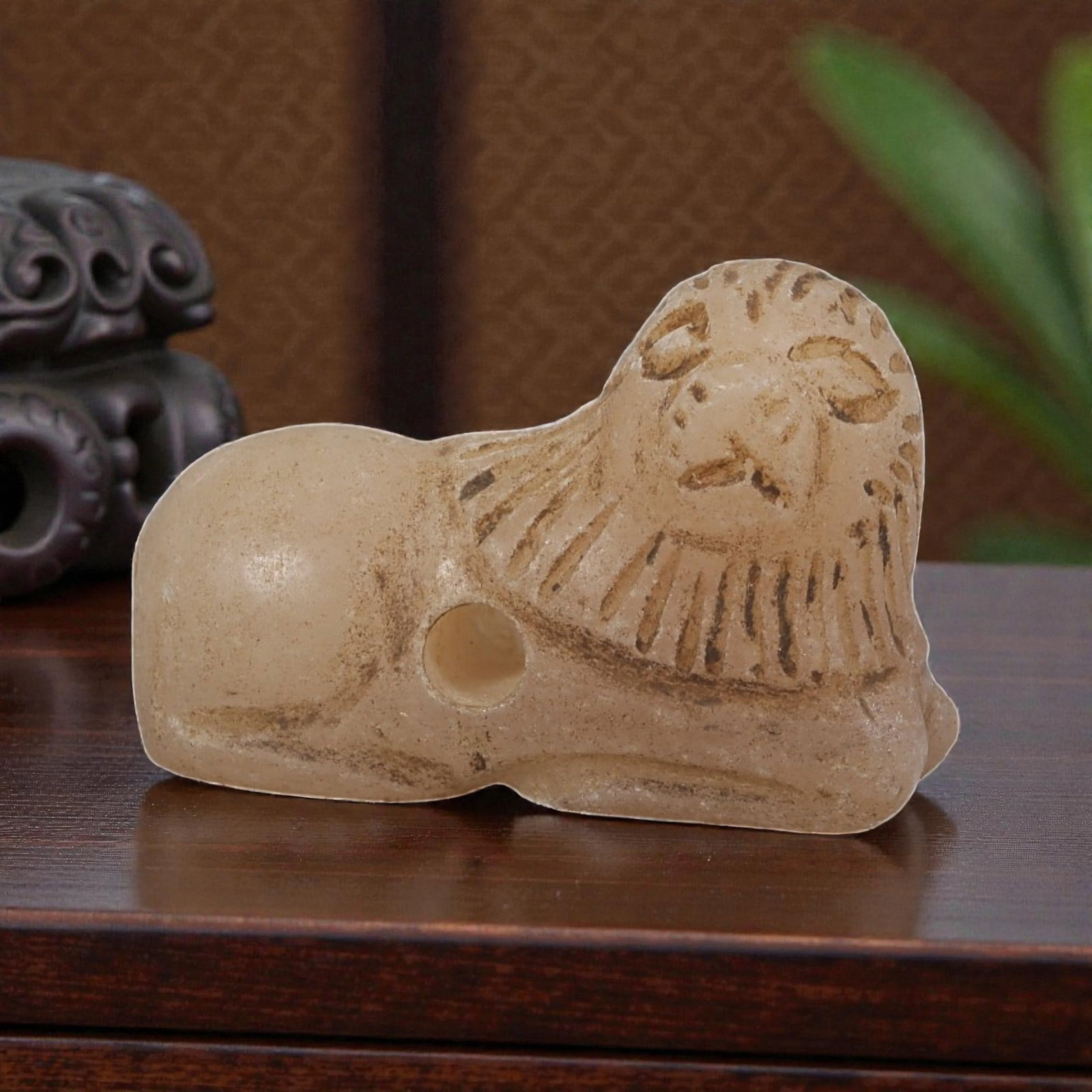 Ancient Bactrian Zoomorphic Stone Lion Amulet, Circa 3rd-2nd Millennium BCE, 84YD: This ancient zoomorphic amulet is carved from pale, creamy stone, depicting a stylized recumbent lion figure. The form features incised details defining the eyes, nose, mouth, and radiating lines repr