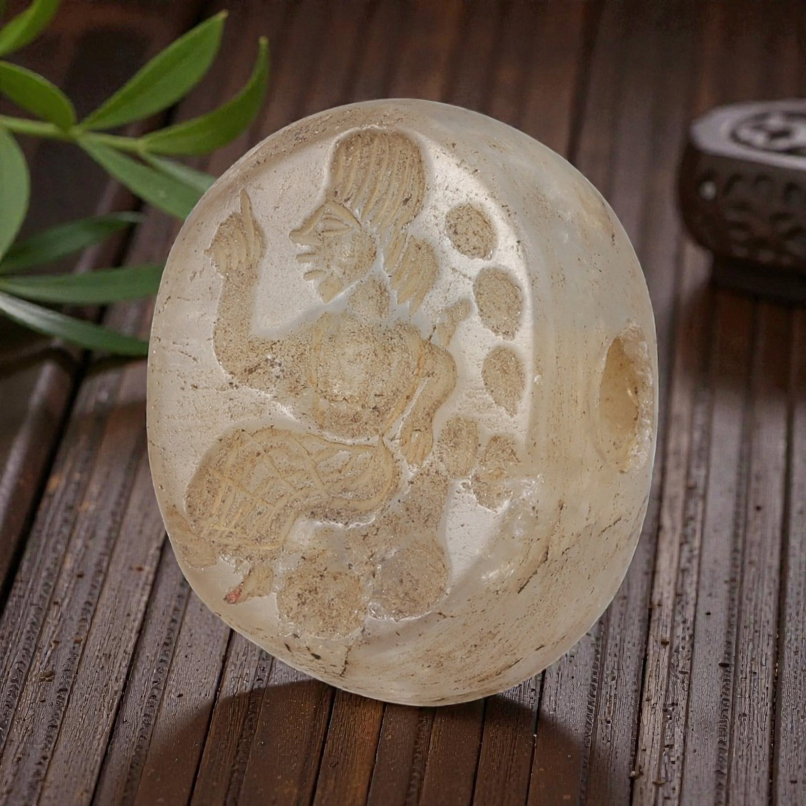 Ancient Sasanian Chalcedony Anthropomorphic Stamp Seal, 75YD: This ancient stamp seal is carved from translucent chalcedony, with a domed, barrel-shaped form and a central perforation for suspension. The flat face features a deeply engraved intaglio depicting a 