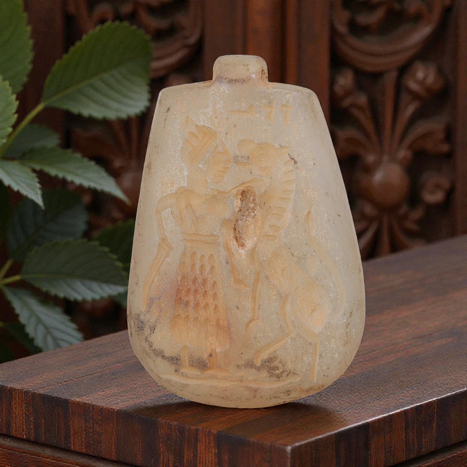 Ancient Sasanian Chalcedony Amulet Pendant, 60YD: This ancient amulet pendant is carved from translucent pale chalcedony, with a teardrop-shaped form and suspension lug at the top. The face features a deeply engraved intaglio depicting a standing fig