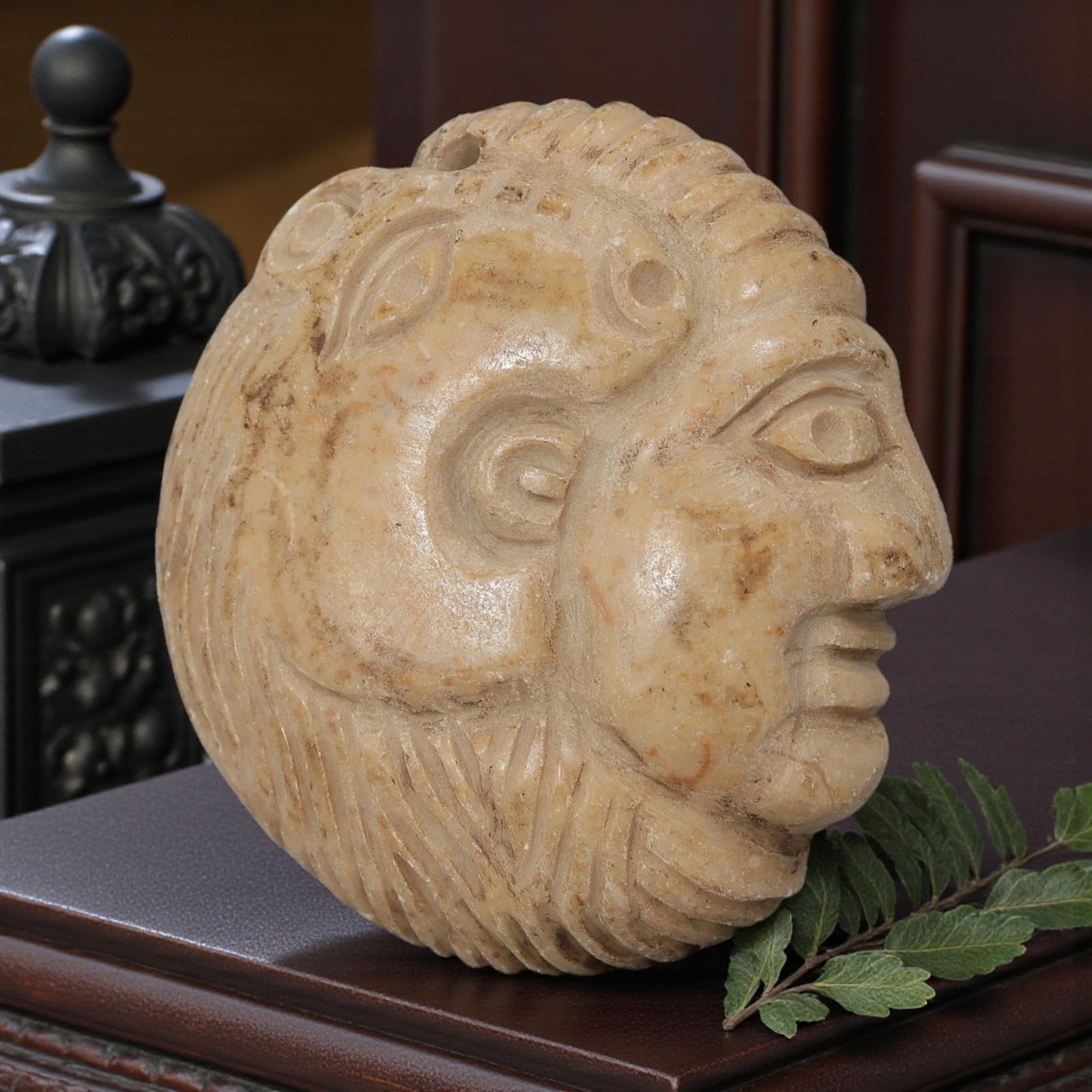 Antique Egyptian Steatite Intaglio with Profile Head Motif, 42AP: Carved from pale beige steatite, this rounded composite profile head depicts both human and feline features, with deeply incised linear patterns representing the mane and facial details. The iconograp