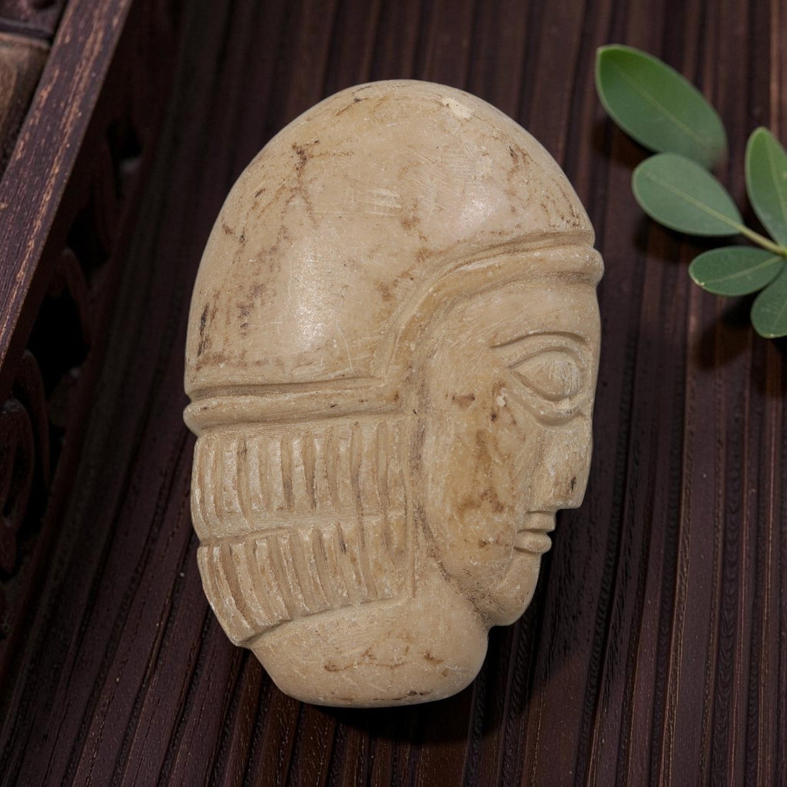 Antique Egyptian Steatite Intaglio with Profile Head Motif, 35AP: Carved from pale beige steatite, this oval profile head features a smooth, rounded headdress and incised linear patterns representing the hairstyle, alongside defined facial features including almond-