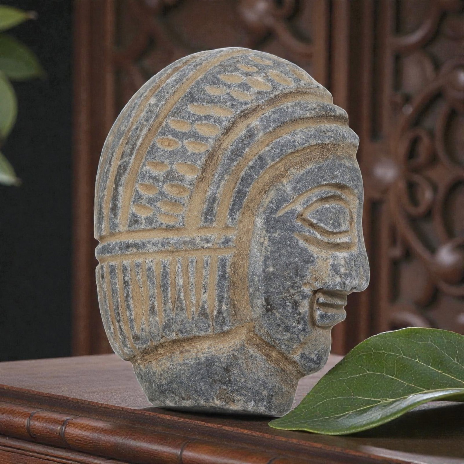 Antique Egyptian Schist Intaglio with Profile Head Motif, 38AP: Carved from dark grey schist, this profile head features incised dot and linear patterns representing the headdress and hairstyle, with earthy deposits filling the recessed carvings. The simplified fa