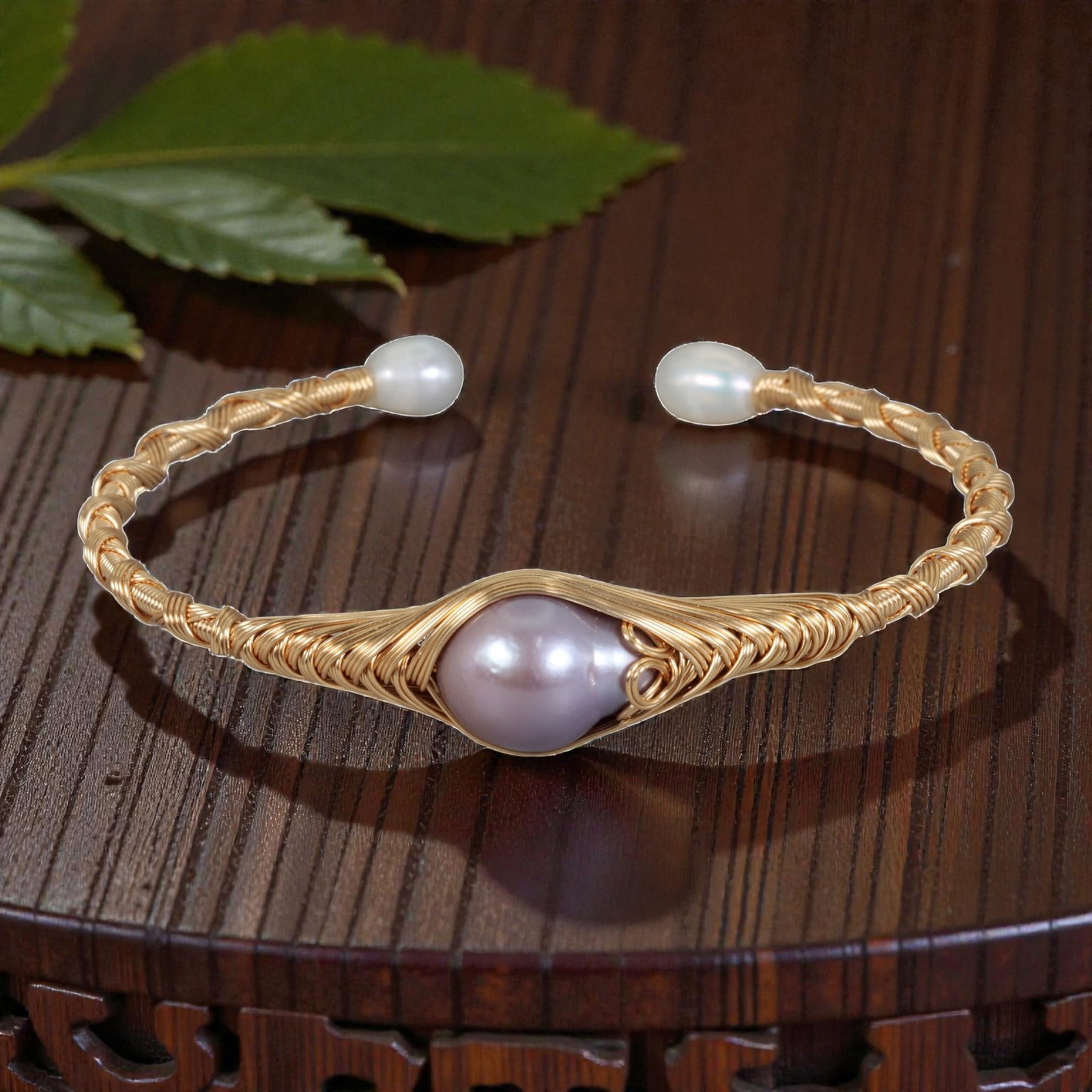 Natural Lavender Freshwater Pearl Gold Wire-Wrapped Open Cuff Bracelet, 22EB: A handcrafted open cuff bracelet made with gold-toned wire, featuring a large teardrop-shaped natural lavender freshwater pearl at the center. The pearl is cradled in an intricately woven wire frame a