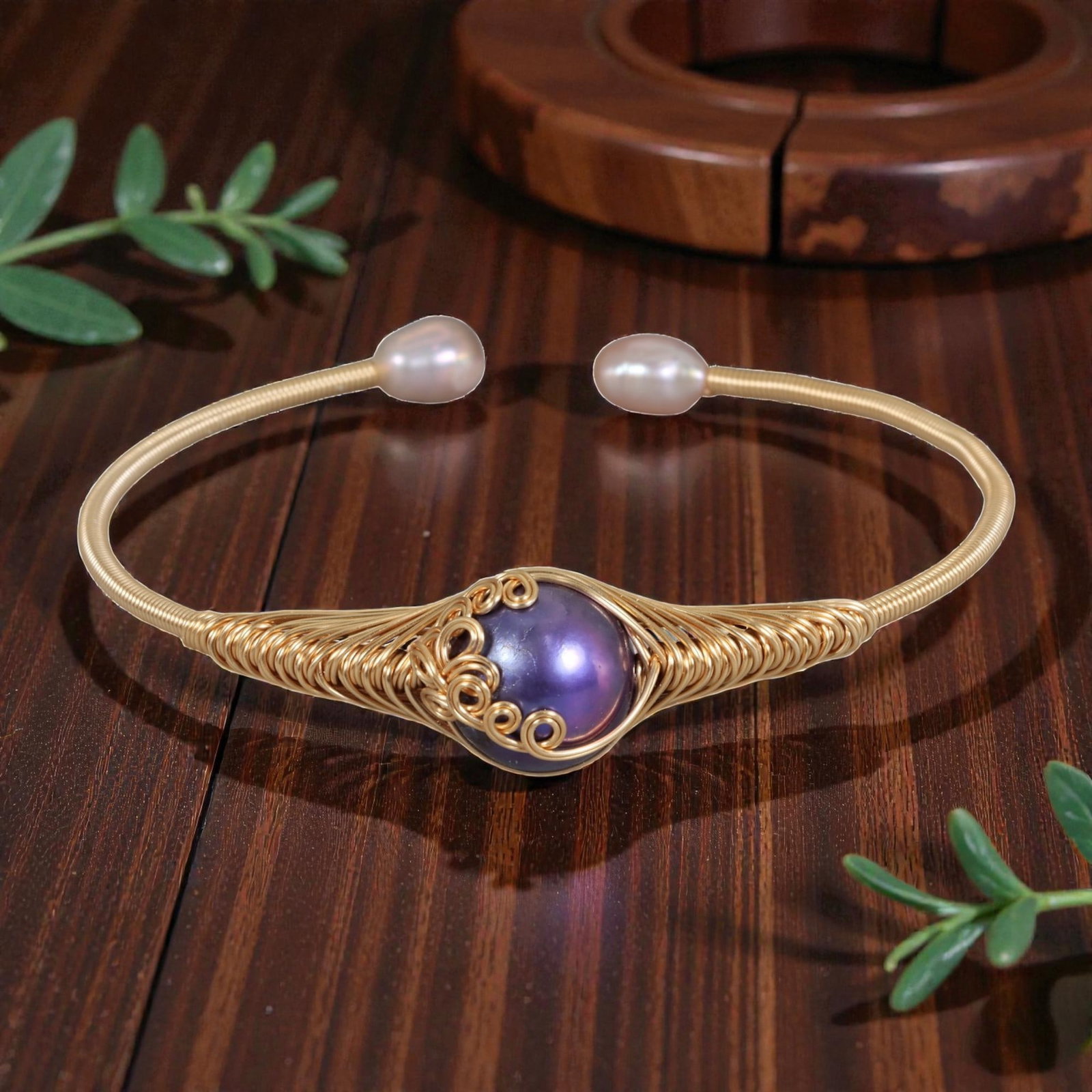 Natural Purple Freshwater Pearl Gold Wire-Wrapped Open Cuff Bracelet, 16EB: A handcrafted open cuff bracelet made with gold-toned wire, intricately woven around a large, round natural purple freshwater pearl at the center. The wire is coiled in a decorative pattern with scrol