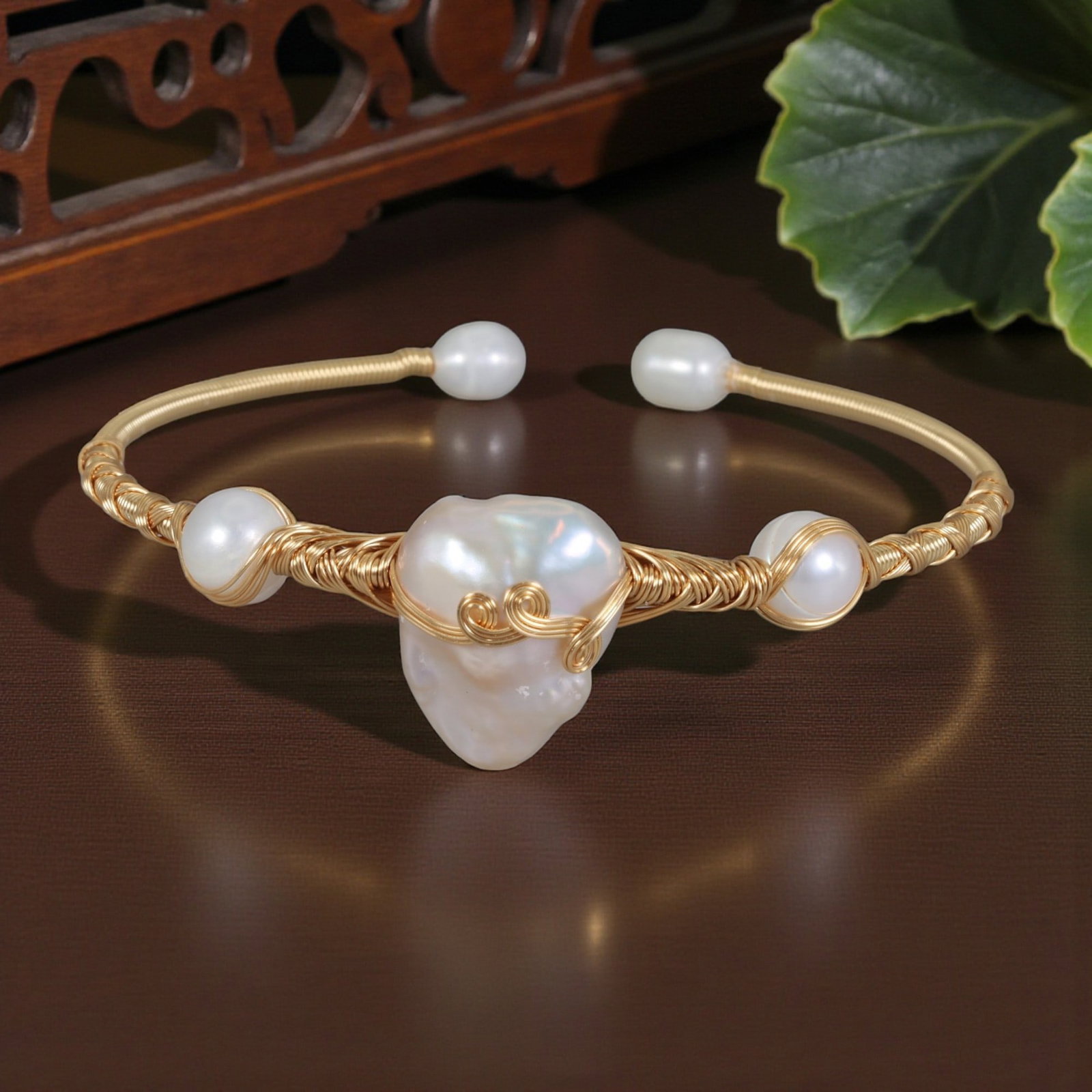 Natural Freshwater Baroque Pearl Gold Wire-Wrapped Open Cuff Bracelet, 25EB: A handcrafted open cuff bracelet made with gold-toned wire, centered on a large natural freshwater baroque pearl. The pearl is secured with intricate wire wrapping and decorative scroll accents, flank