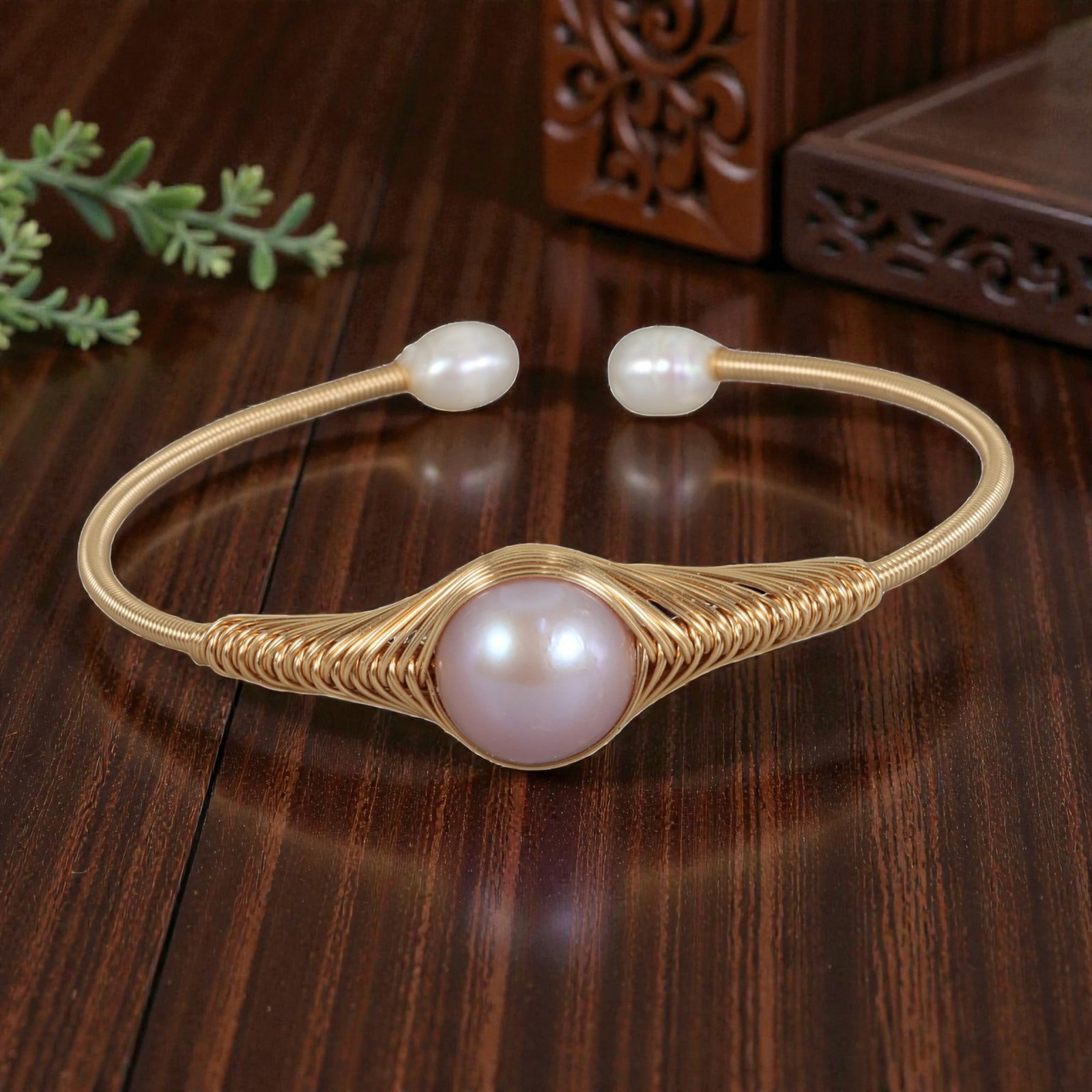 Natural Pink Freshwater Pearl Gold Wire-Wrapped Open Cuff Bracelet, 24EB: A handcrafted open cuff bracelet made with gold-toned wire, intricately woven around a large, round natural pink freshwater pearl at the center. The wire is coiled in a decorative, fan-like pattern ar