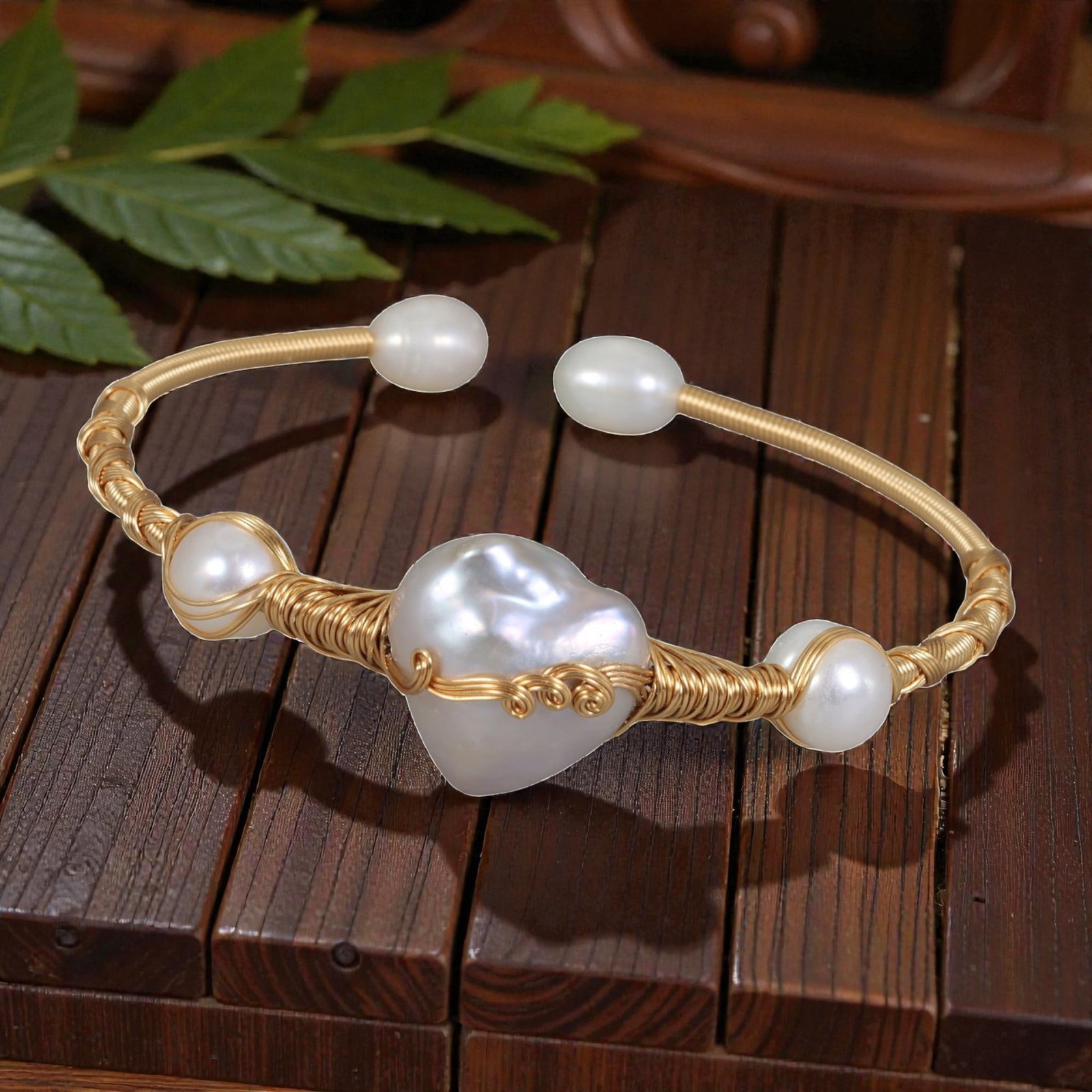 Natural Freshwater Baroque Pearl Gold Wire Open Bangle Bracelet, 7EB: A delicate open-style bangle bracelet handcrafted with gold-finish wire, centered on a large natural freshwater baroque pearl, flanked by smaller round freshwater pearls at the sides and open ends. Th