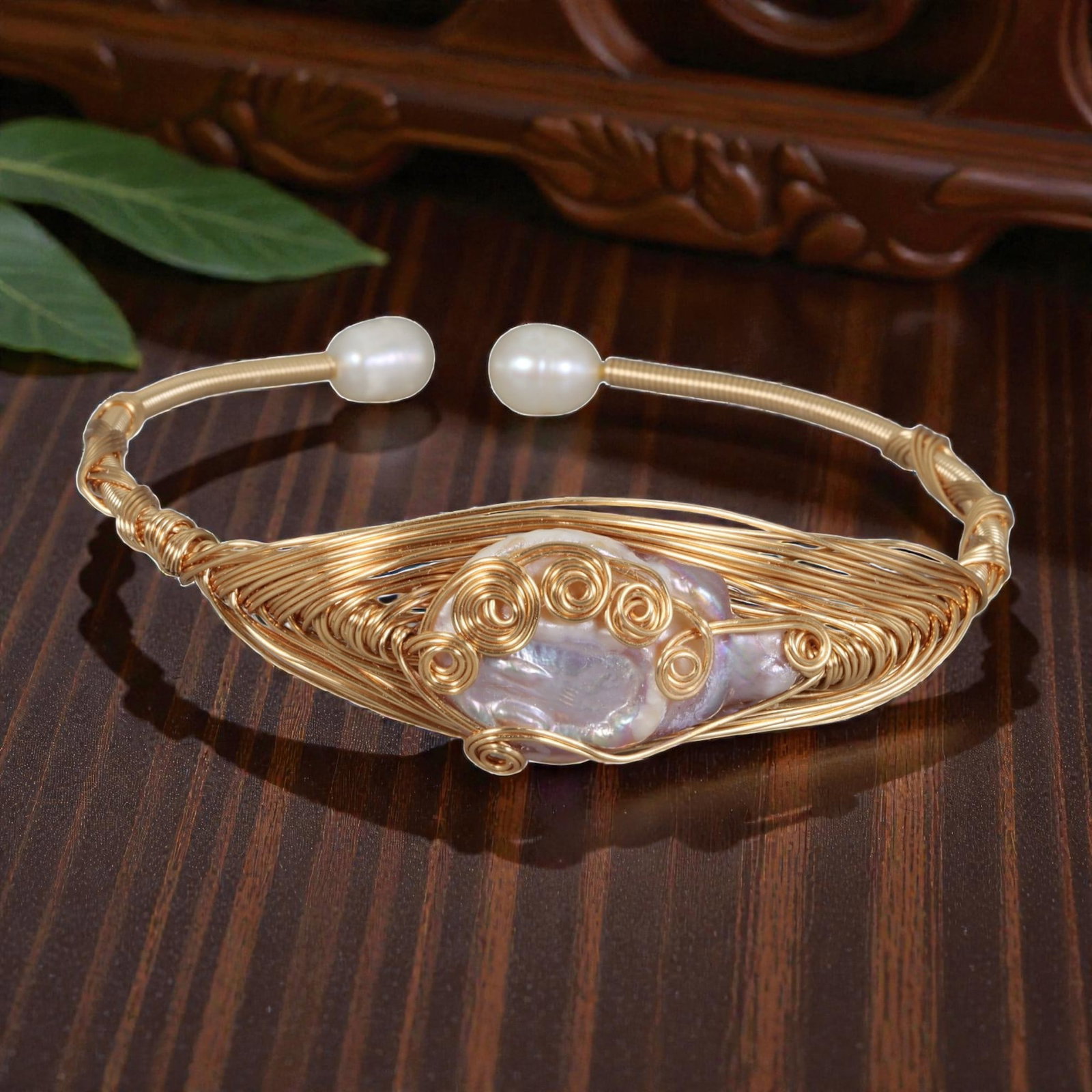 Natural Freshwater Baroque Pearl Gold Wire-Woven Open Cuff Bracelet, 19EB: A handcrafted open cuff bracelet made with gold-toned wire, featuring an intricately woven wire frame that cradles a large natural freshwater baroque pearl at the center. The pearl is accented by deco