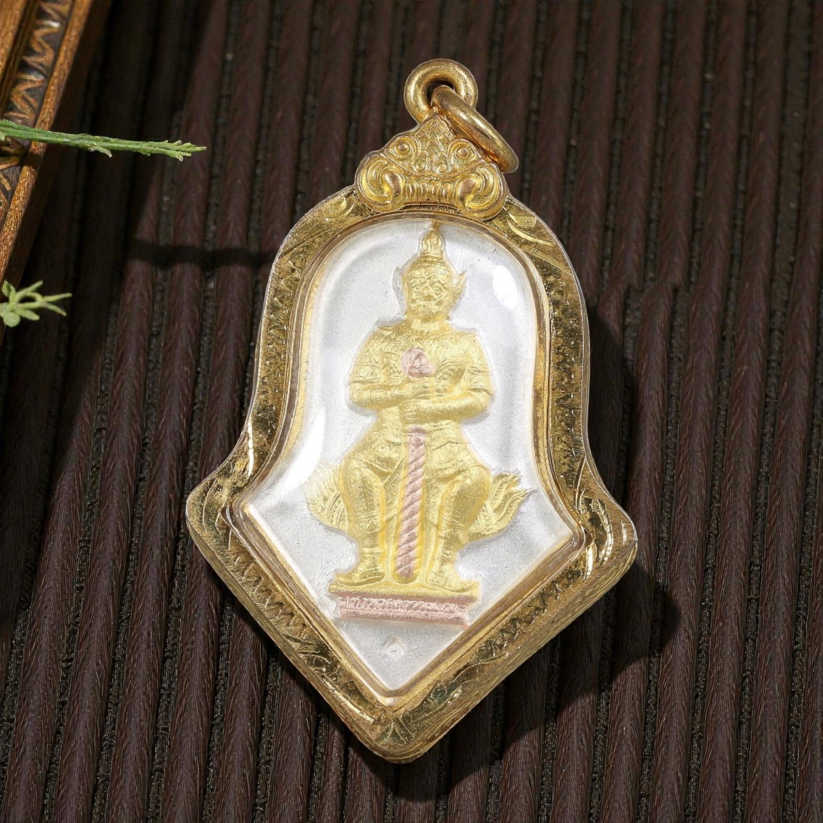 Thai Tewa Guardian Amulet - Gold Tone Pendant, 54ZB: A Thai Buddhist Tewa (guardian deity) amulet featuring a seated divine figure holding a sacred staff, housed in an ornate gold-tone metal casing. The glass-fronted enclosure protects the embossed deit