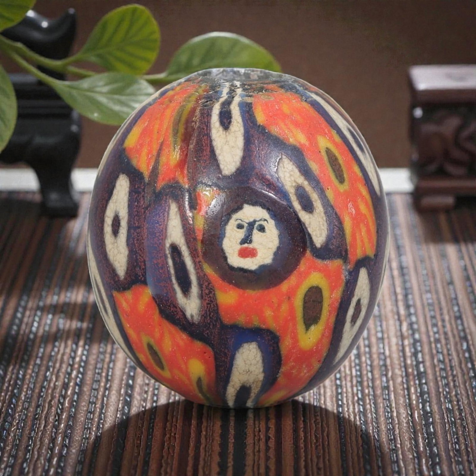 Antique Glass Bead - Islamic Jatim Multicolor Human Face Mosaic, 68YH: A spherical glass bead of Islamic Jatim type, crafted from polychrome mosaic glass. The surface features a unique design with stylized human face motifs at the center of eye-like elements, framed by l