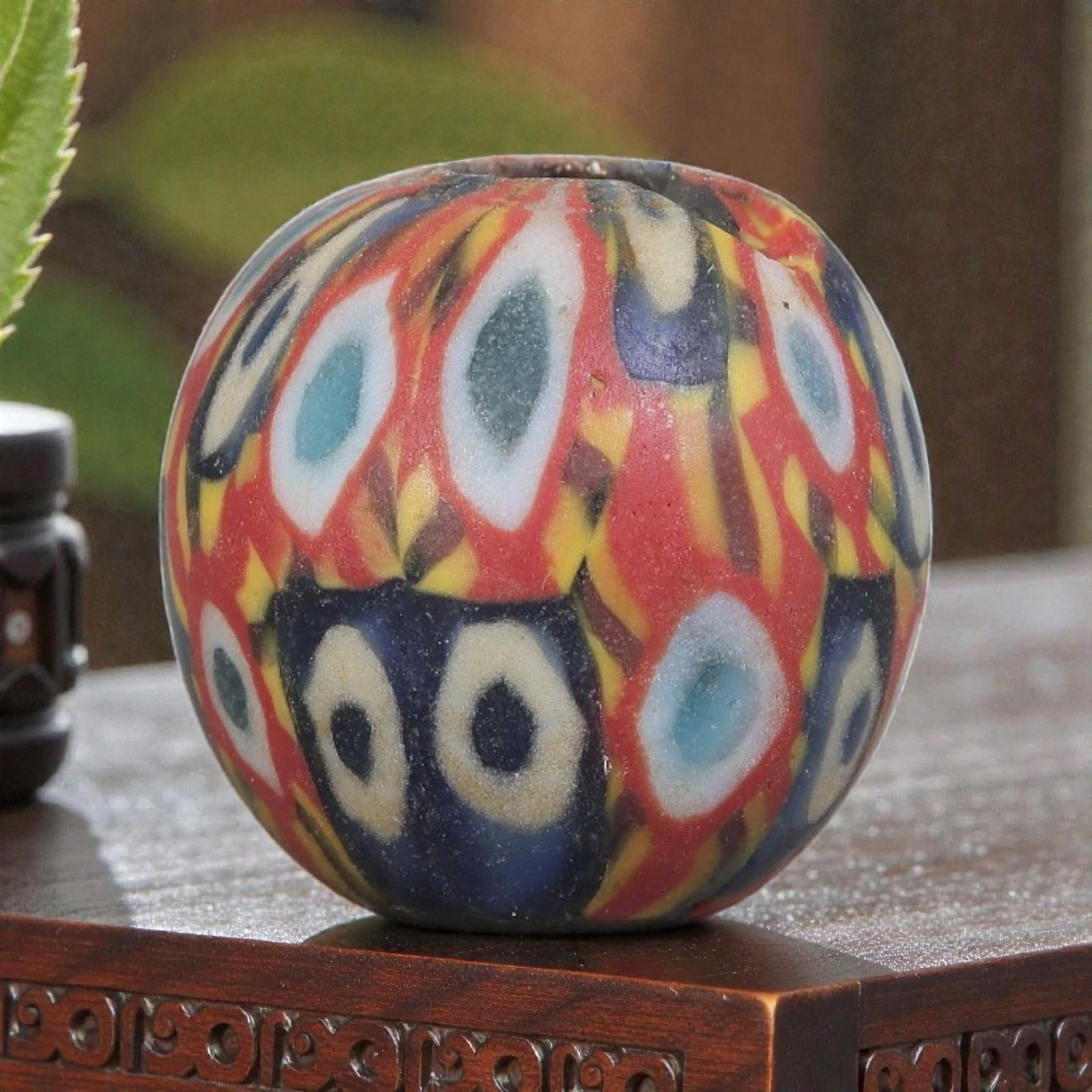 Antique Glass Bead - Islamic Jatim Multicolor Eye Mosaic, 63YH: A spherical glass bead of Islamic Jatim type, crafted from polychrome mosaic glass. The surface features repeating eye motifs in two distinct color schemes: one with light blue centers framed by white
