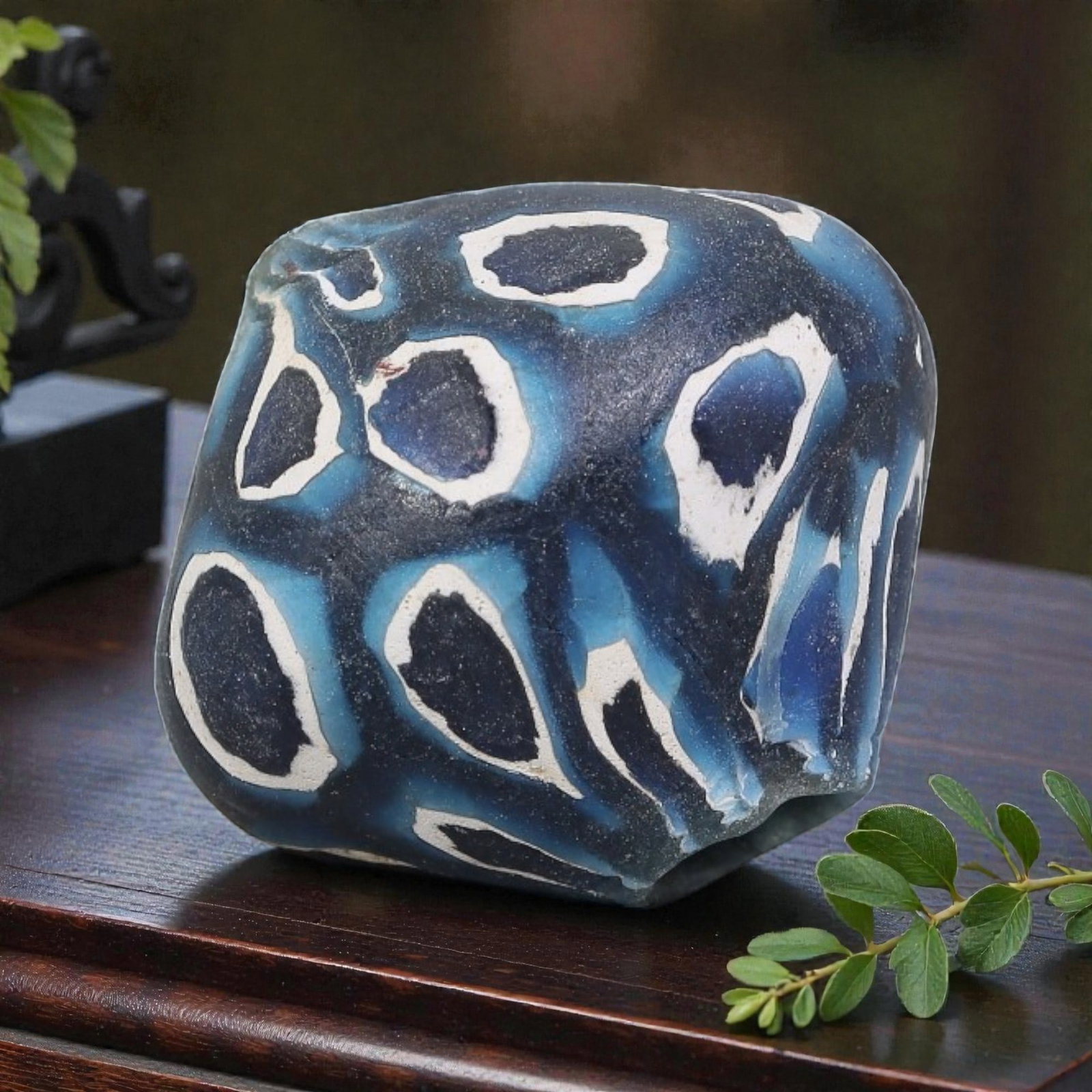 Antique Glass Bead - Islamic Jatim Blue-White Eye Mosaic, 55YH: A rounded, irregular glass bead of Islamic Jatim type, crafted from polychrome mosaic glass. The surface features bold, irregular eye motifs with deep blue centers framed by white borders, set against