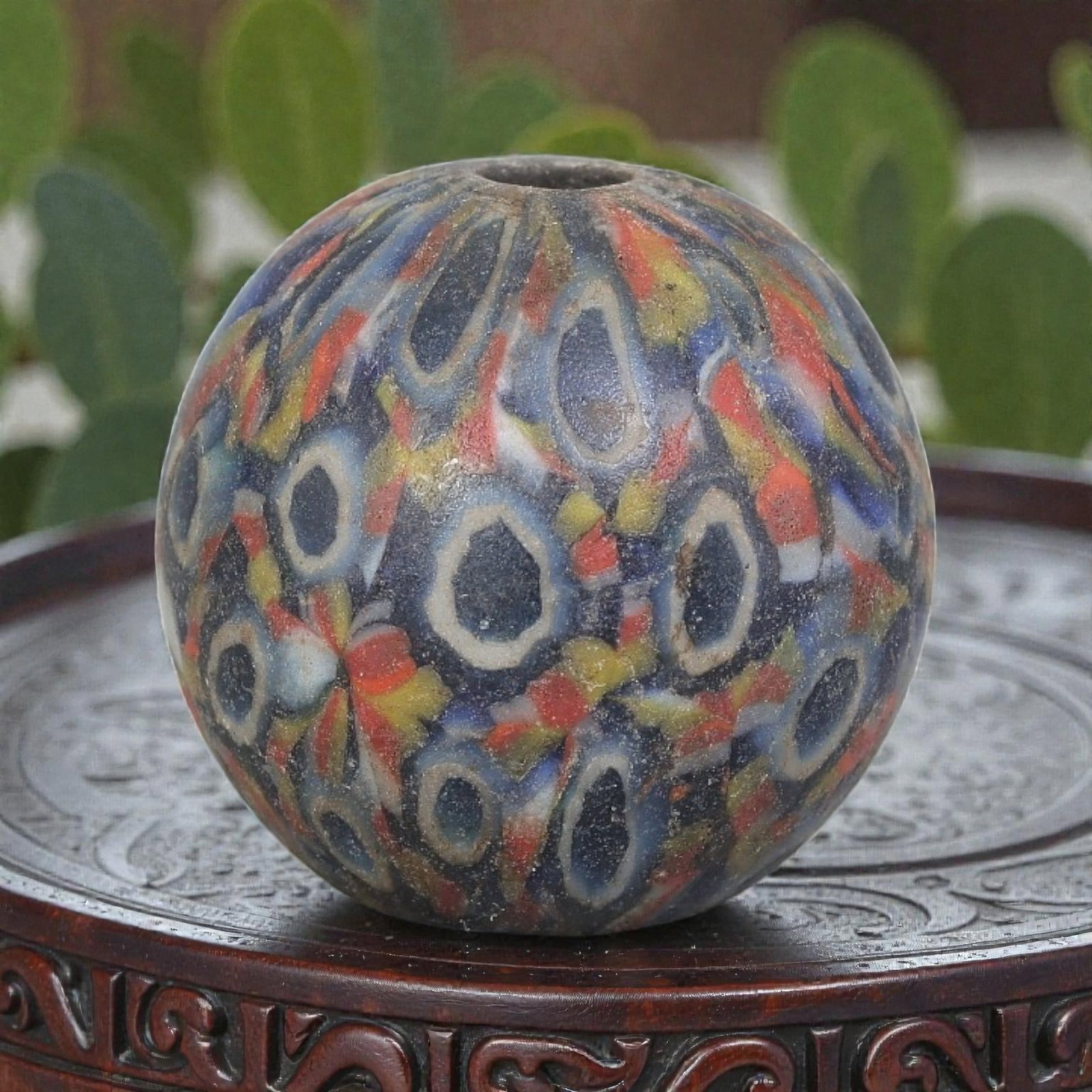 Antique Glass Bead - Islamic Jatim Multicolor Eye Mosaic, 50YH: A spherical glass bead of Islamic Jatim type, crafted from polychrome mosaic glass. The surface features repeating eye motifs with dark centers and light rings, set against a richly colored ground int