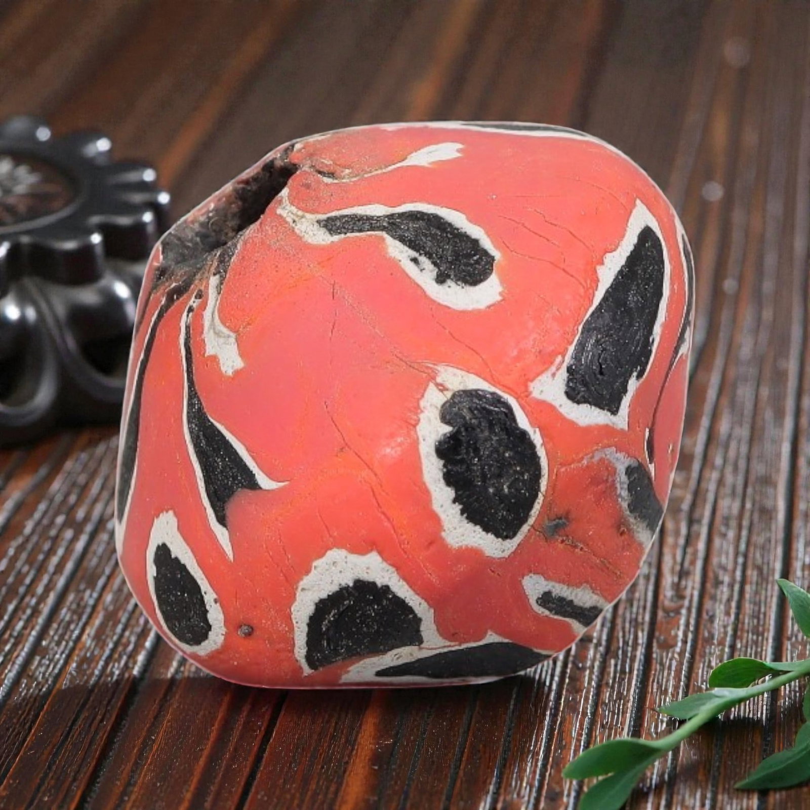 Antique Glass Bead - Islamic Jatim Red-Black Eye Mosaic, 62YH: A spherical glass bead of Islamic Jatim type, crafted from polychrome mosaic glass. The surface features bold, irregular eye motifs with black centers framed by white borders, set against a vibrant co