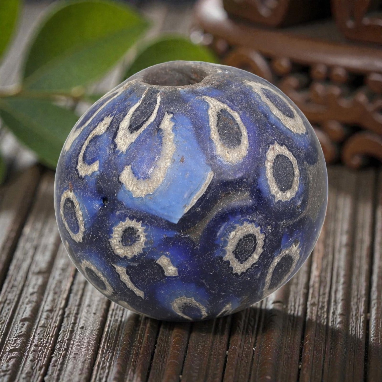 Antique Glass Bead - Islamic Jatim Cobalt Peacock Eye Mosaic, 77AP: A spherical glass bead of Islamic Jatim type, crafted from polychrome mosaic glass. The surface features repeating peacock eye motifs with serrated white borders and dark centers, set against a rich c