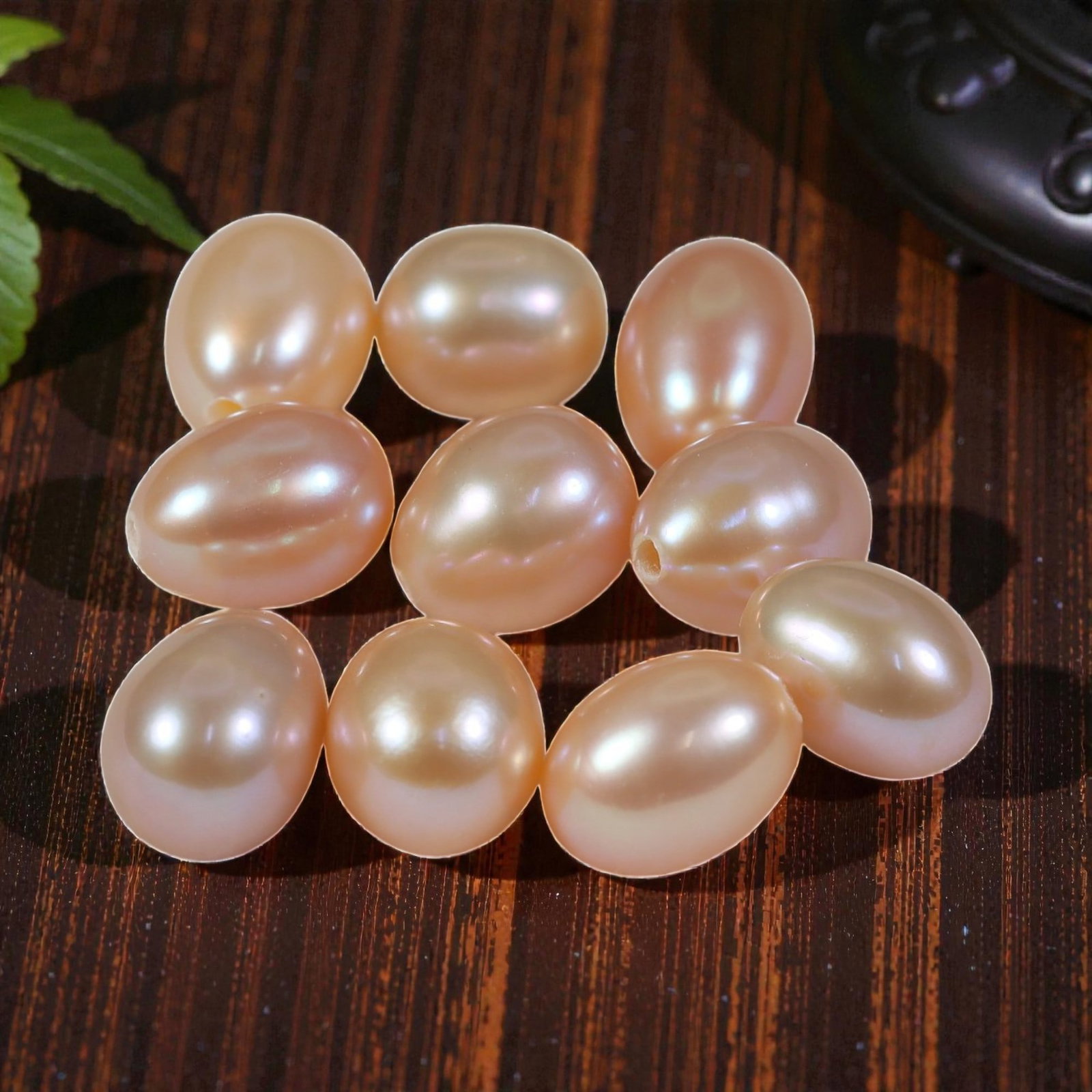 19.42ct Natural Fresh Water Pearl Drilled, 23YH: This is a drilled, natural freshwater pearl, showcasing a soft, warm peach-pink hue with a smooth, polished surface and gentle iridescence. The pearl features a classic oval shape with a consistent, e