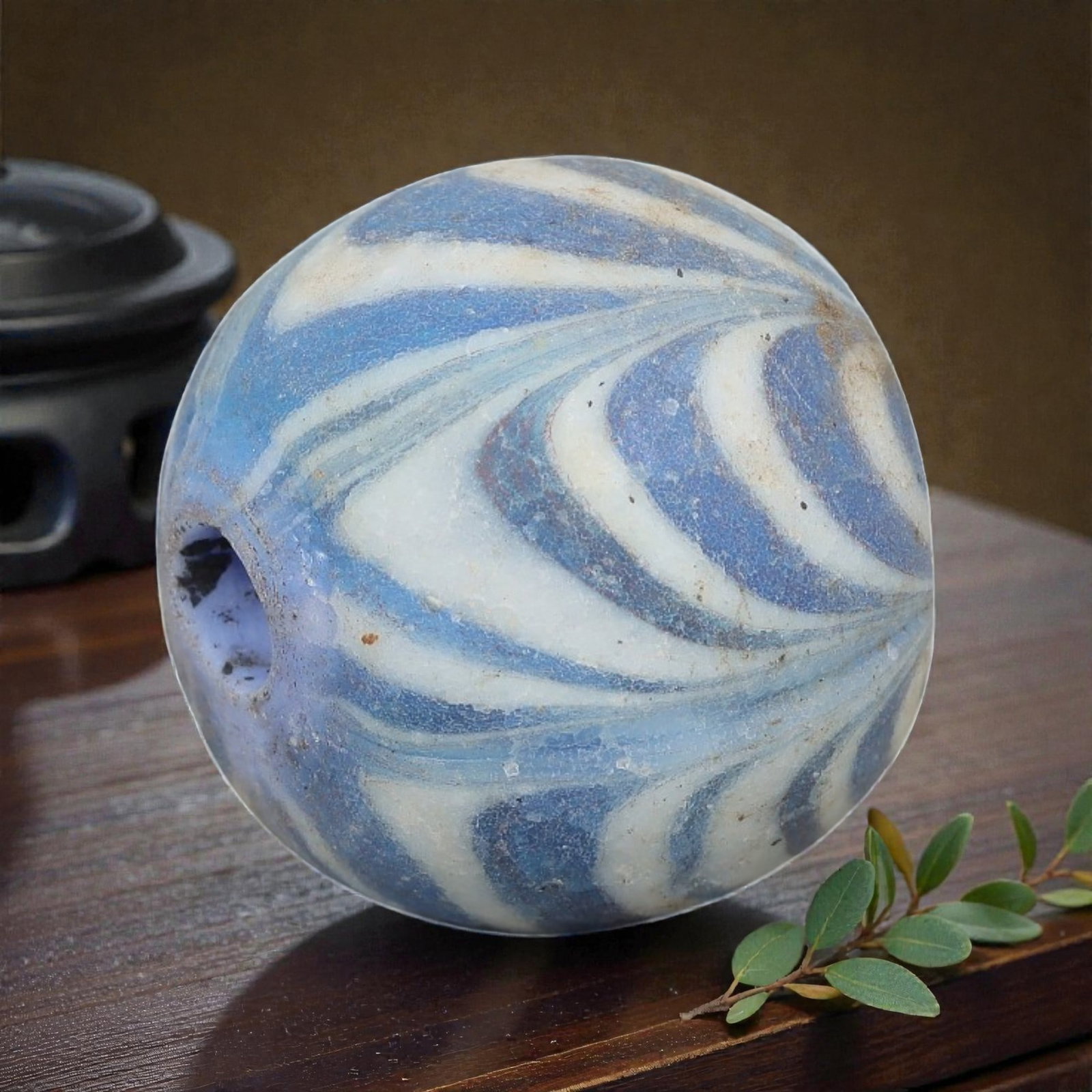 Antique Glass Bead - Islamic Jatim Blue & White Swirl, 76AP: A spherical glass bead of Islamic Jatim type, crafted from polychrome marvered glass. The surface features an intricate blue and white swirl pattern, with fluid, layered bands of varying shades of blu