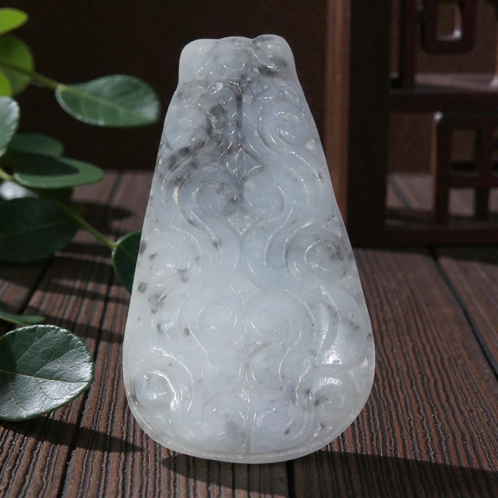 A Vintage Oriental Chinese Jadeite Jade Carved Pendant, 21AG: Carved from pale greyish-white jadeite jade with natural dark inclusions and marbling, the pendant is of teardrop form with raised relief scrollwork carved symmetrically across its surface. The design