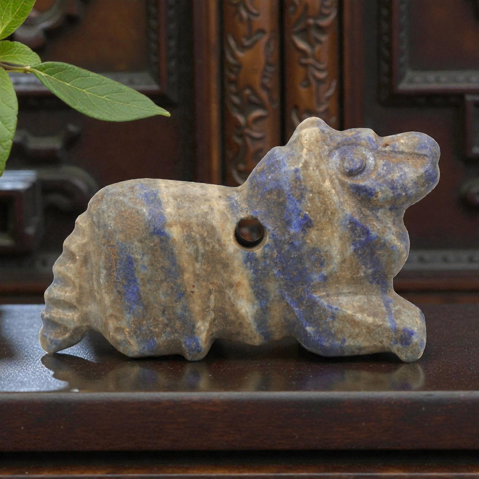 Ancient Lapis Lazuli Zoomorphic Amulet - Near Eastern Figurine, 25ZR: This artifact is a carved lapis lazuli zoomorphic amulet, executed in the stylized animal tradition of the ancient Near East. The amulet depicts a recumbent quadruped (likely a lion or canine) with si