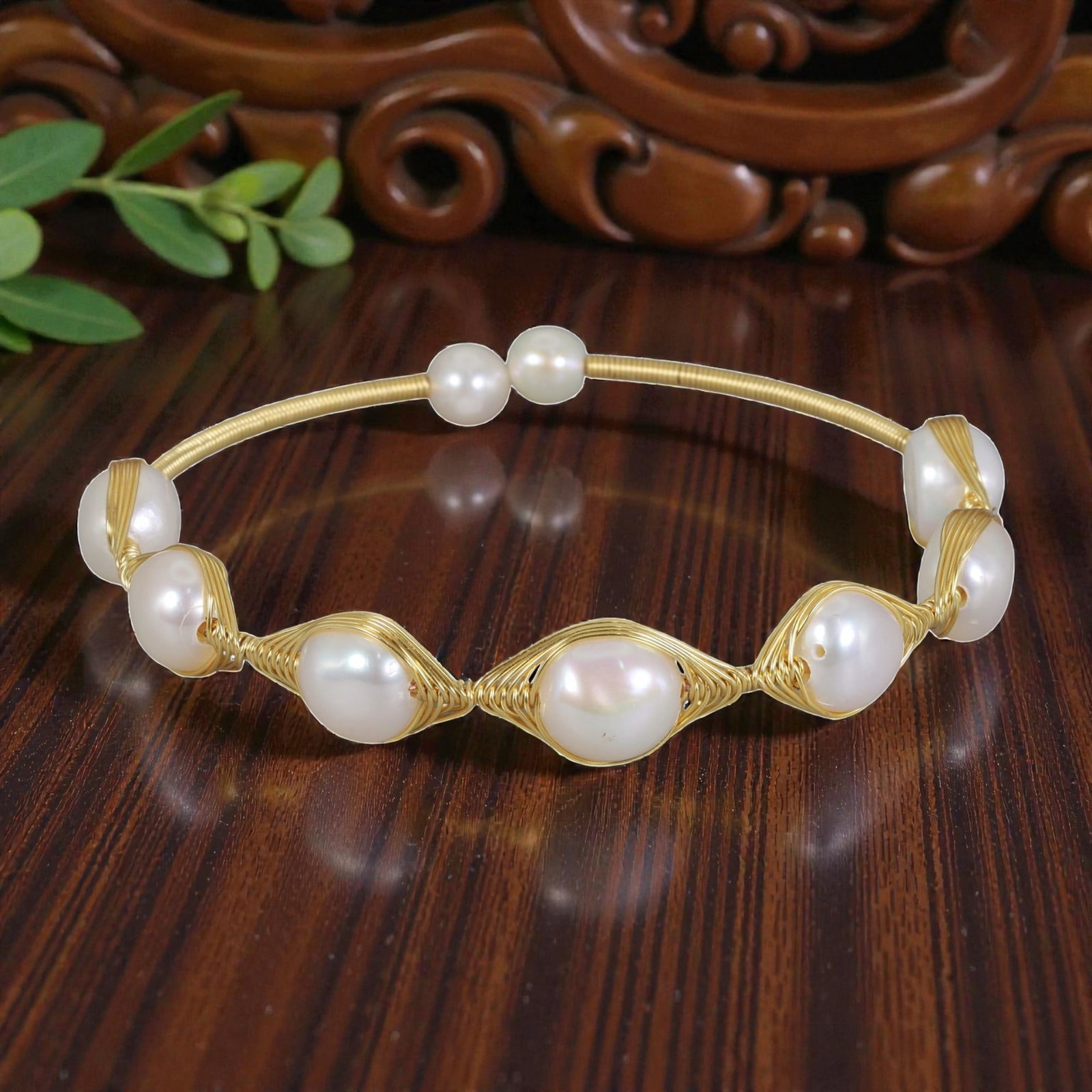 Natural Freshwater Pearl Gold Wire-Wrapped Open Cuff Bracelet, 12EB: A handcrafted open cuff bracelet made with gold-toned wire, featuring seven natural white freshwater pearls arranged along the front. The pearls are secured in varying wire-wrapped settings-some simpl