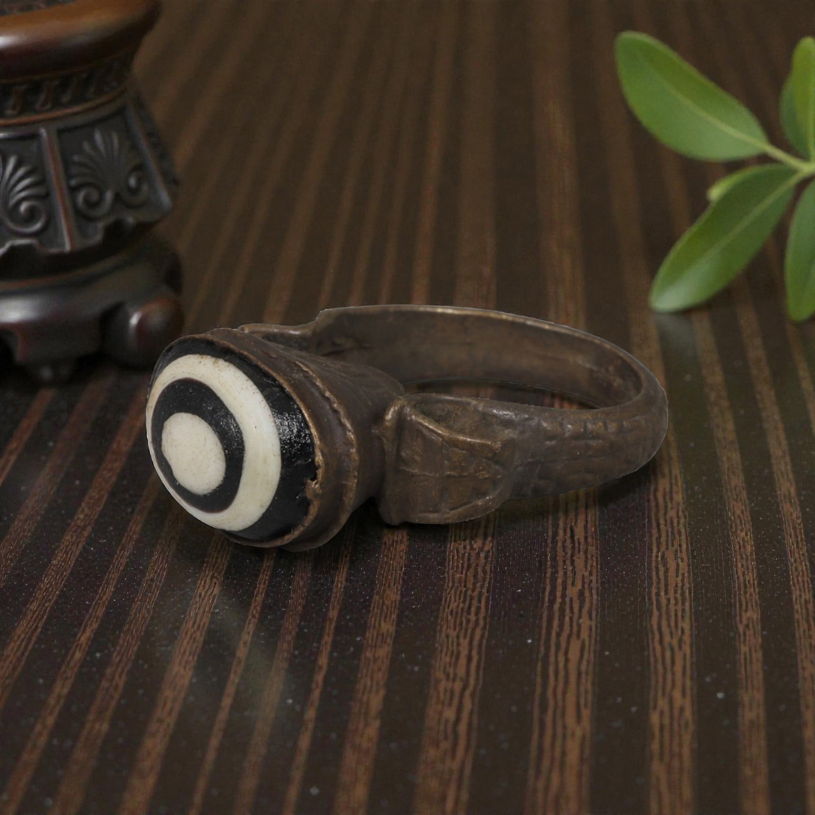 Antique Qajar Dynasty Bronze Evil Eye Ring, US Size 9, 19AJ: A bronze ring of the Qajar period, US ring size 9, featuring a domed evil-eye glass inlay with a striking concentric black-and-white pattern. The glass exhibits age-related patina and wear consistent 
