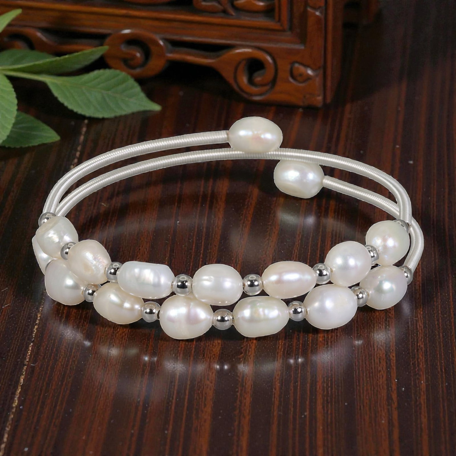 Natural Freshwater Pearl Silver Tone Double-Wire Cuff Bracelet, 14EB: A delicate open cuff bracelet crafted with silver tone double wire, adorned with a lush arrangement of natural freshwater pearls. The pearls are interspersed with small silver-toned spacer beads, crea
