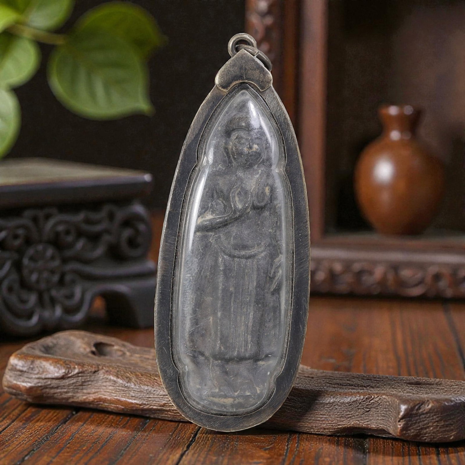 Thai Standing Buddha Amulet - Silver Tone Pendant, 46AP: A Thai Buddhist amulet featuring a carved standing Buddha figure, housed in a dark silver-tone metal casing with a glass-fronted enclosure. The Buddha plaque exhibits an aged, patinated surface consis