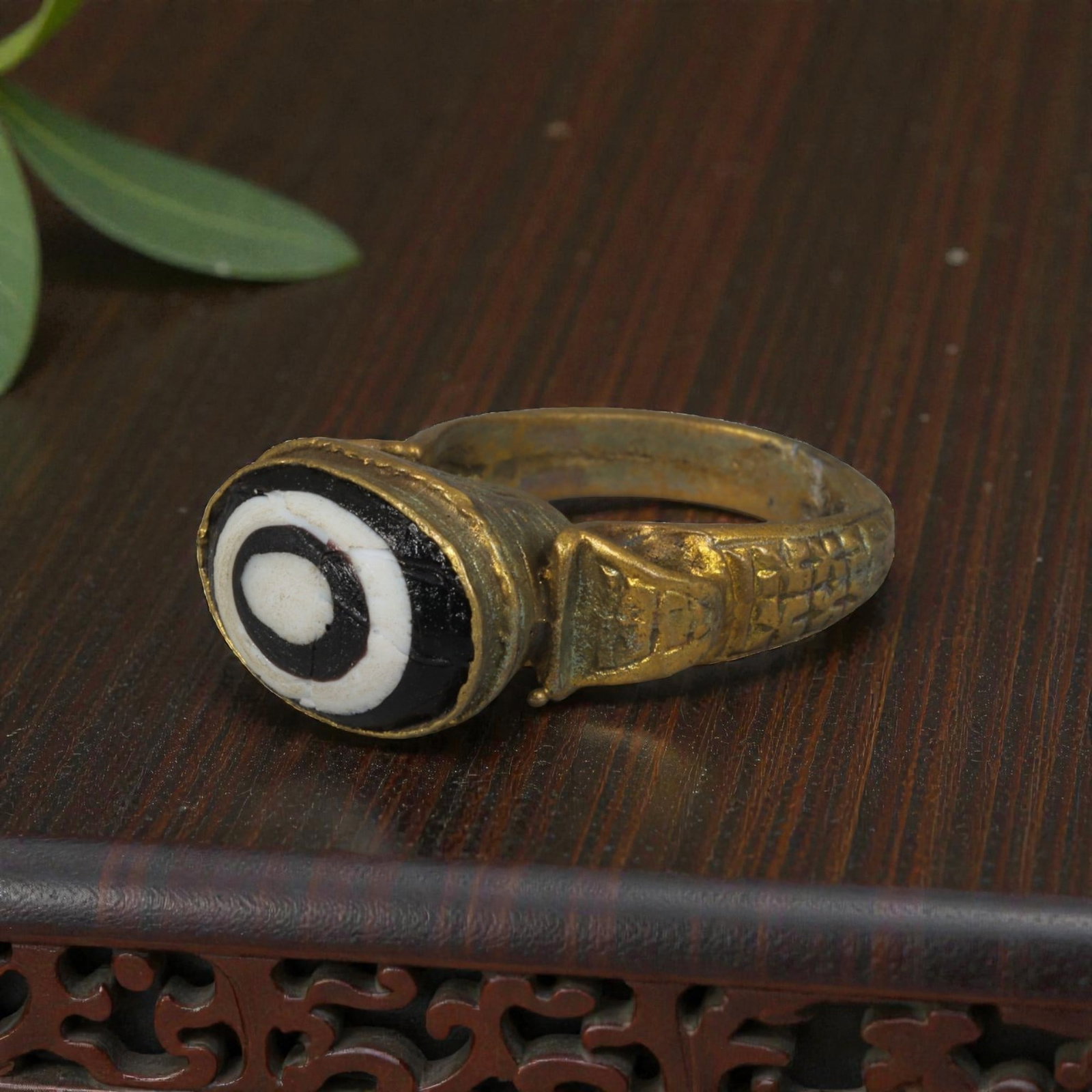 Antique Qajar Dynasty Gilt Evil Eye Ring, US Size 9, 12AJ: A gilt-metal ring of the Qajar period, US ring size 9, featuring an oval evil-eye glass inlay with a bold concentric black-and-white design (the glass exhibits age-related cracks). The domed bezel and