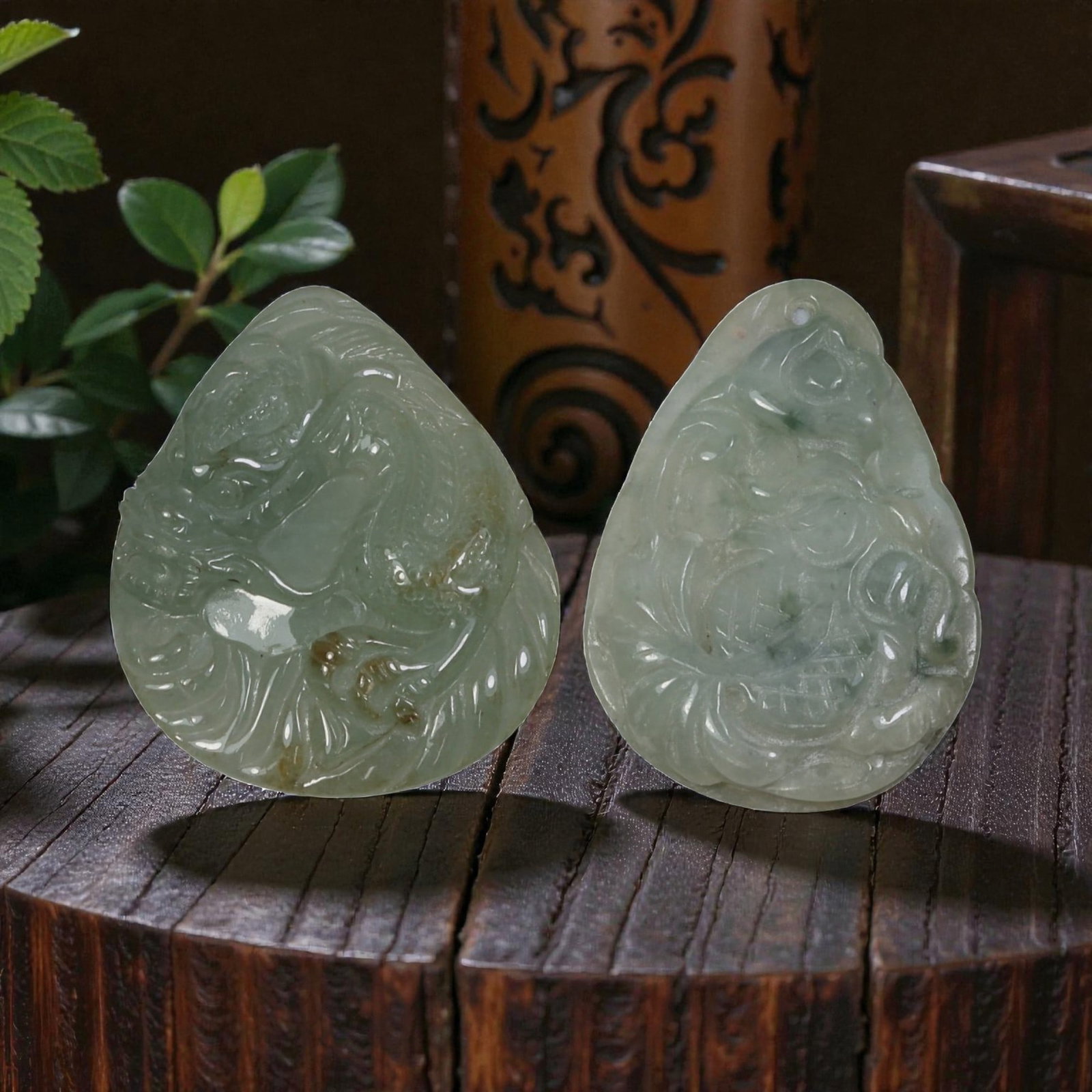 Lot of 2 Antique Oriental Chinese Jadeite Jade Pendants, 24AG: The lot comprises two teardrop-shaped jadeite pendants, each carved from pale green stone with natural tonal variations and inclusions. The left pendant features a high-relief carving of a mythical be