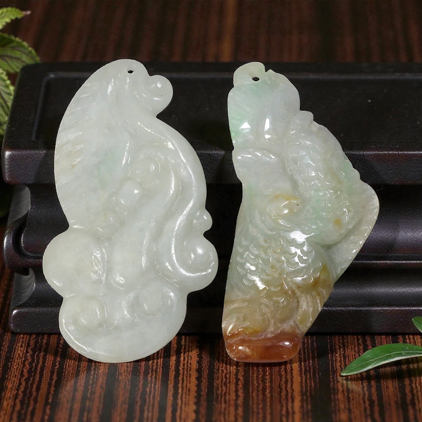 Lot of 2 Antique Oriental Chinese Jadeite Jade Pendants, 49AG: The lot comprises two free-form jadeite pendants. The left pendant is carved from pale milky-white jadeite with faint green inclusions, featuring stylized ruyi scroll motifs and integrated suspension 