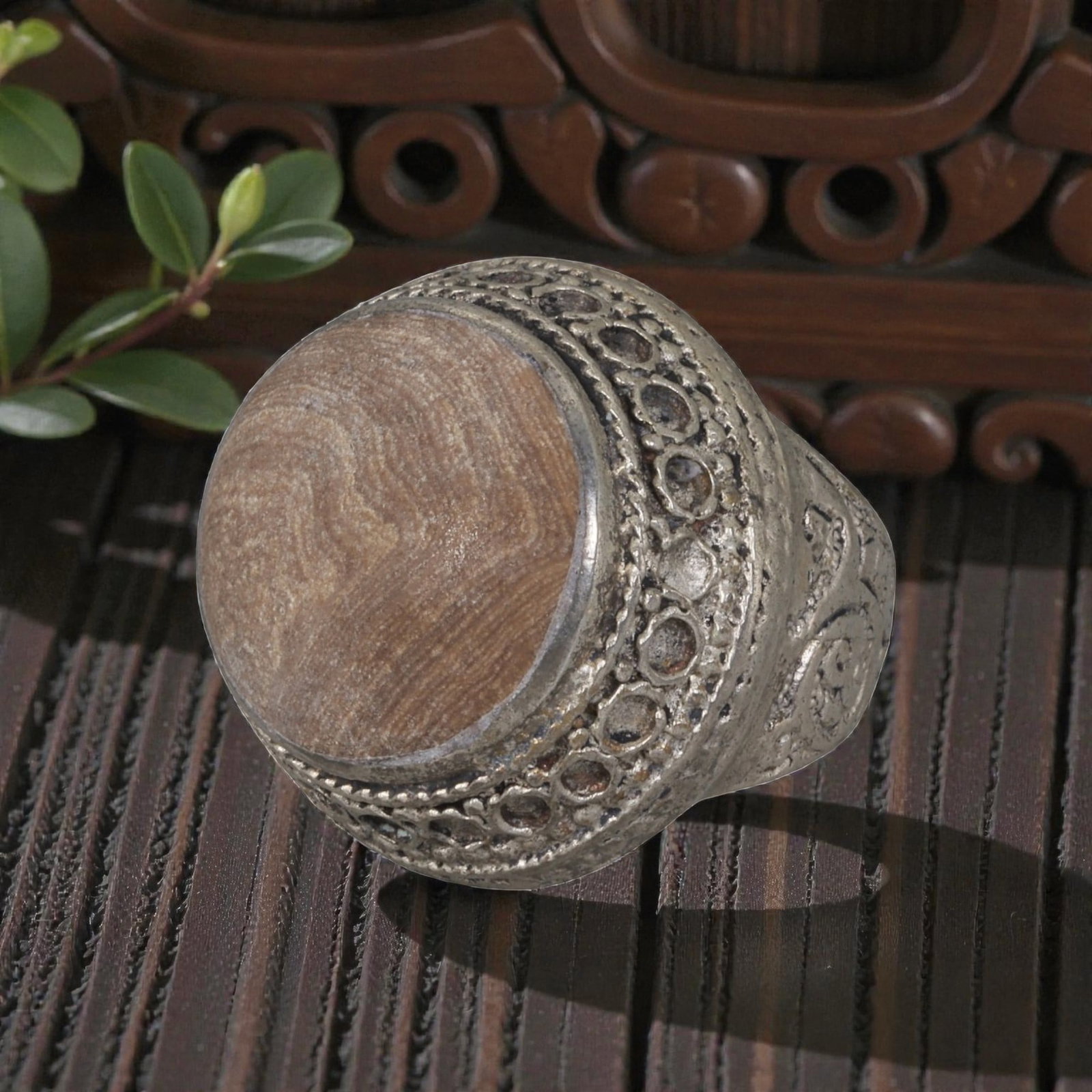 A Middle Eastern Silver Plated Banded Agate Ring, Late 19th-Early 20th Century, 28AK: The ring is centered with a large round cabochon banded agate stone exhibiting natural layered brown and beige striations, set within a wide domed bezel decorated with openwork circular patterns and t