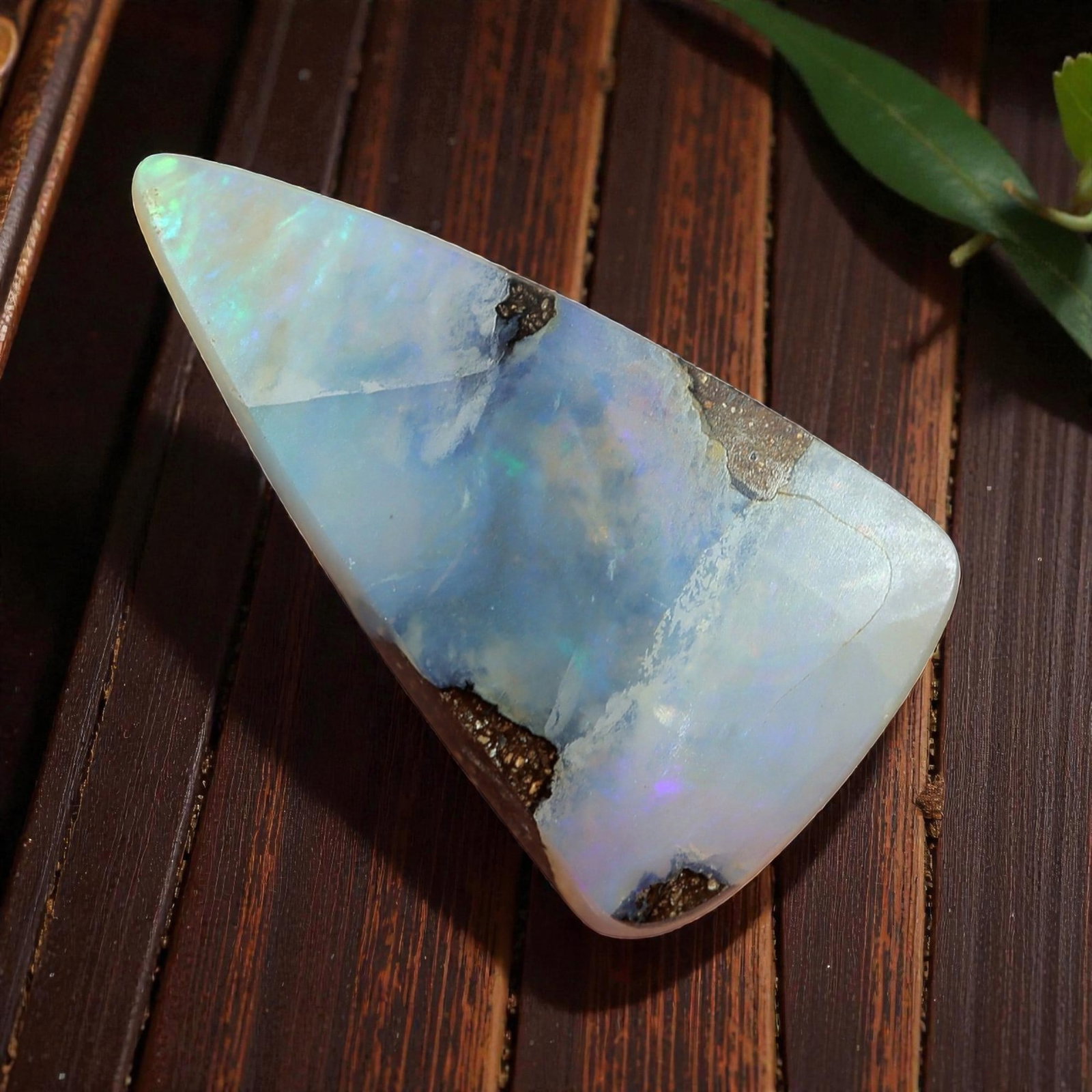 2.15 Carats Boulder Opal Cabochon - Soft Pastel Play-of-Color Specimen, 60XM: This 2.15ct boulder opal cabochon, measuring 12x7mm, is a delicate example of Australia's iconic gemstone, showcasing the ethereal beauty of nature's artistry. The freeform triangular cabochon is poli