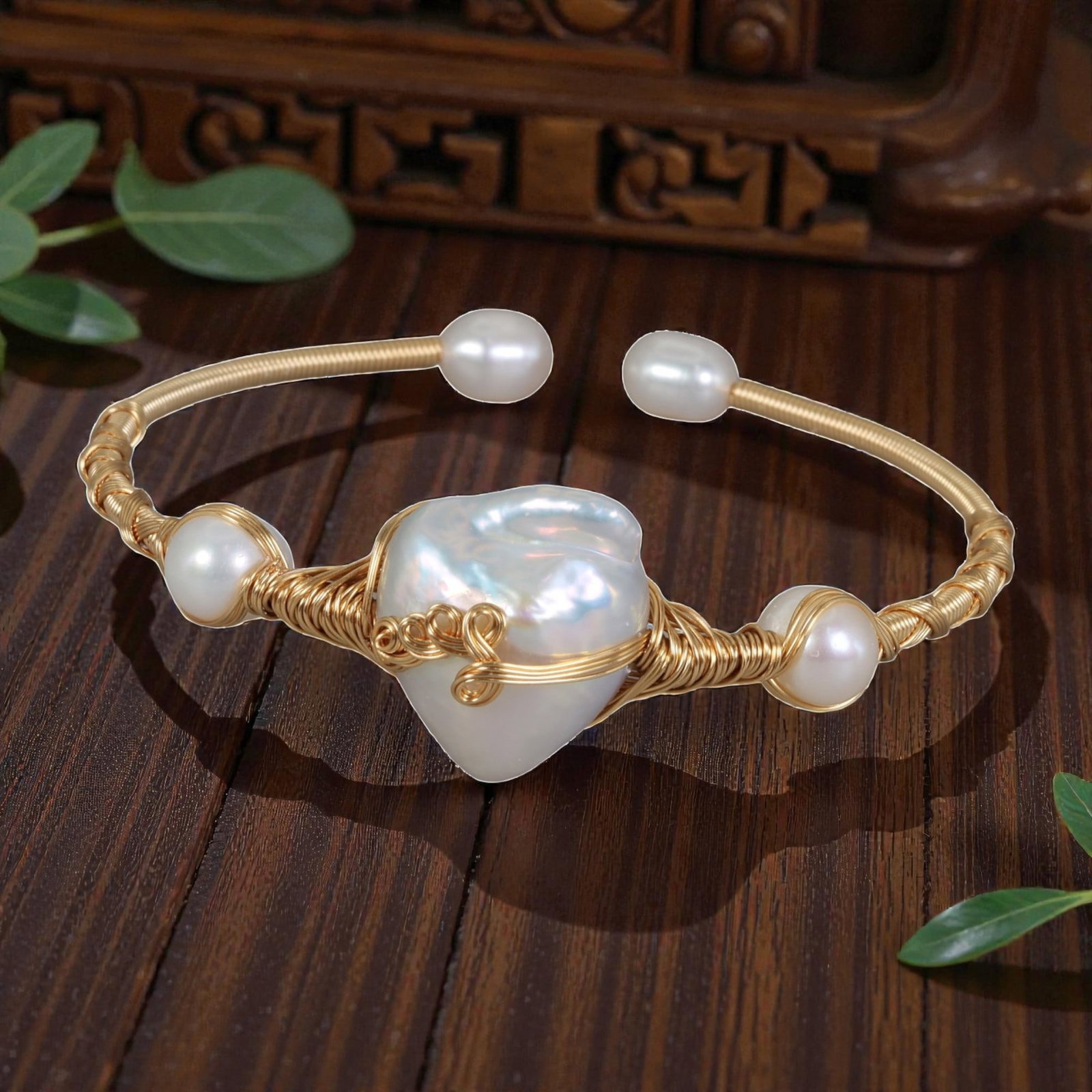 Natural Freshwater Baroque Pearl Gold Wire-Wrapped Open Cuff Bracelet, 15EB: A handcrafted open cuff bracelet made with gold-toned wire, centered on a large natural freshwater baroque pearl, flanked by smaller round freshwater pearls at the sides and open ends. The wire is int