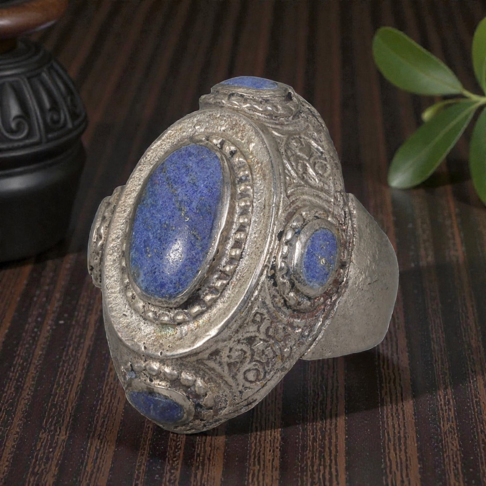 A Middle Eastern Silver Plated Multi-Stone Lapis Lazuli Ring, Late 19th-Early 20th Century, 37AK: Set with a central oval cabochon lapis lazuli stone exhibiting deep blue color with natural pyrite flecks, the ring is accented by four smaller lapis lazuli stones arranged around the bezel. The centr