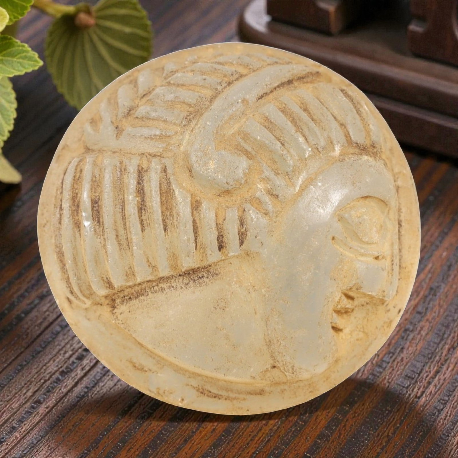 Ancient Glass Medieval Amulet - Near Eastern Relic, 89AL: This artifact is crafted from ancient glass, molded into a circular form and carved in relief with a profile human head, featuring detailed facial features and stylized hair with incised linear patter