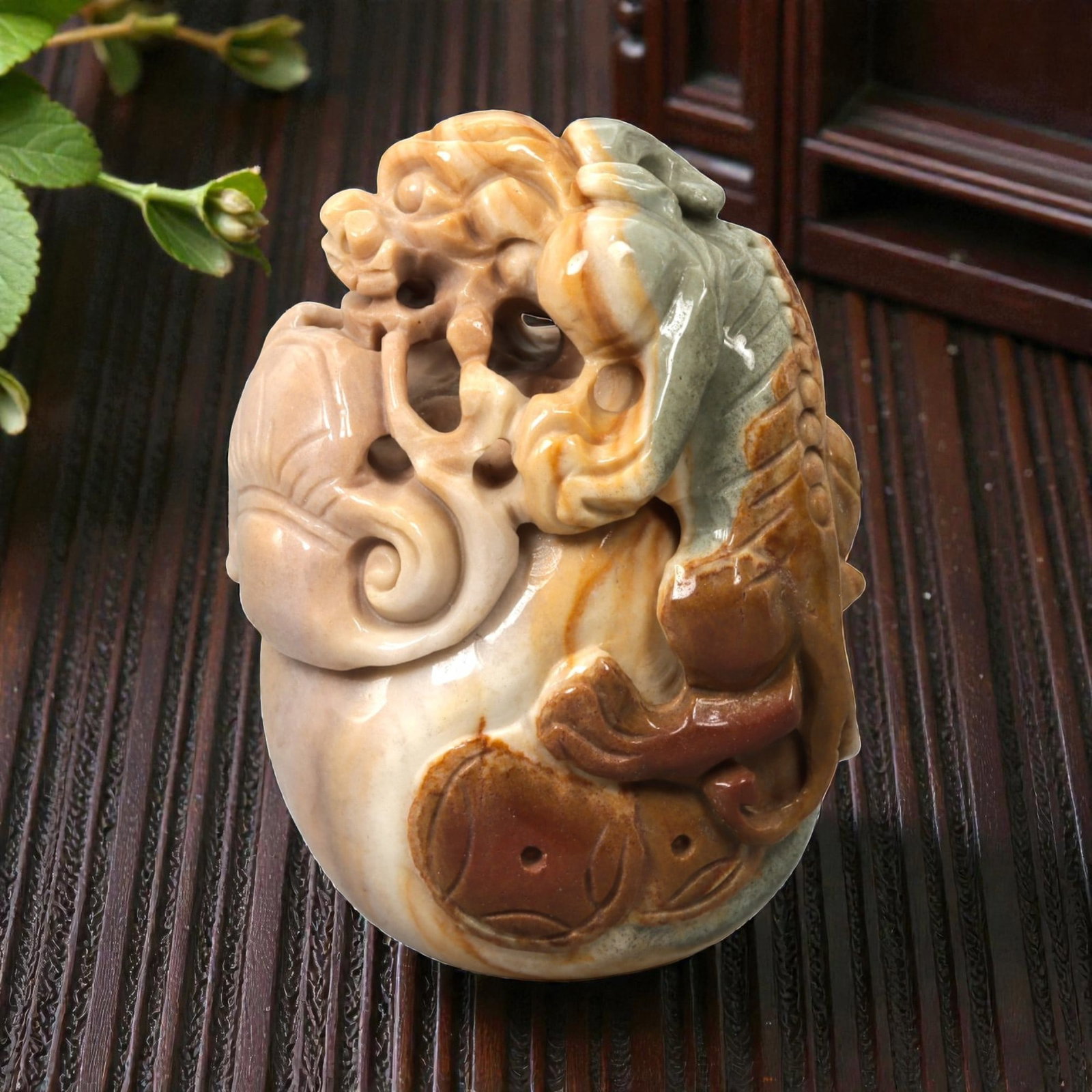 A Chinese Hardstone Mythical Beast Carving, 20th Century, 31FC: Carved from variegated hardstone with cream, russet, and pale green tones, the object is worked as a compact sculptural composition representing a mythical beast in the round. The creature is shown cr