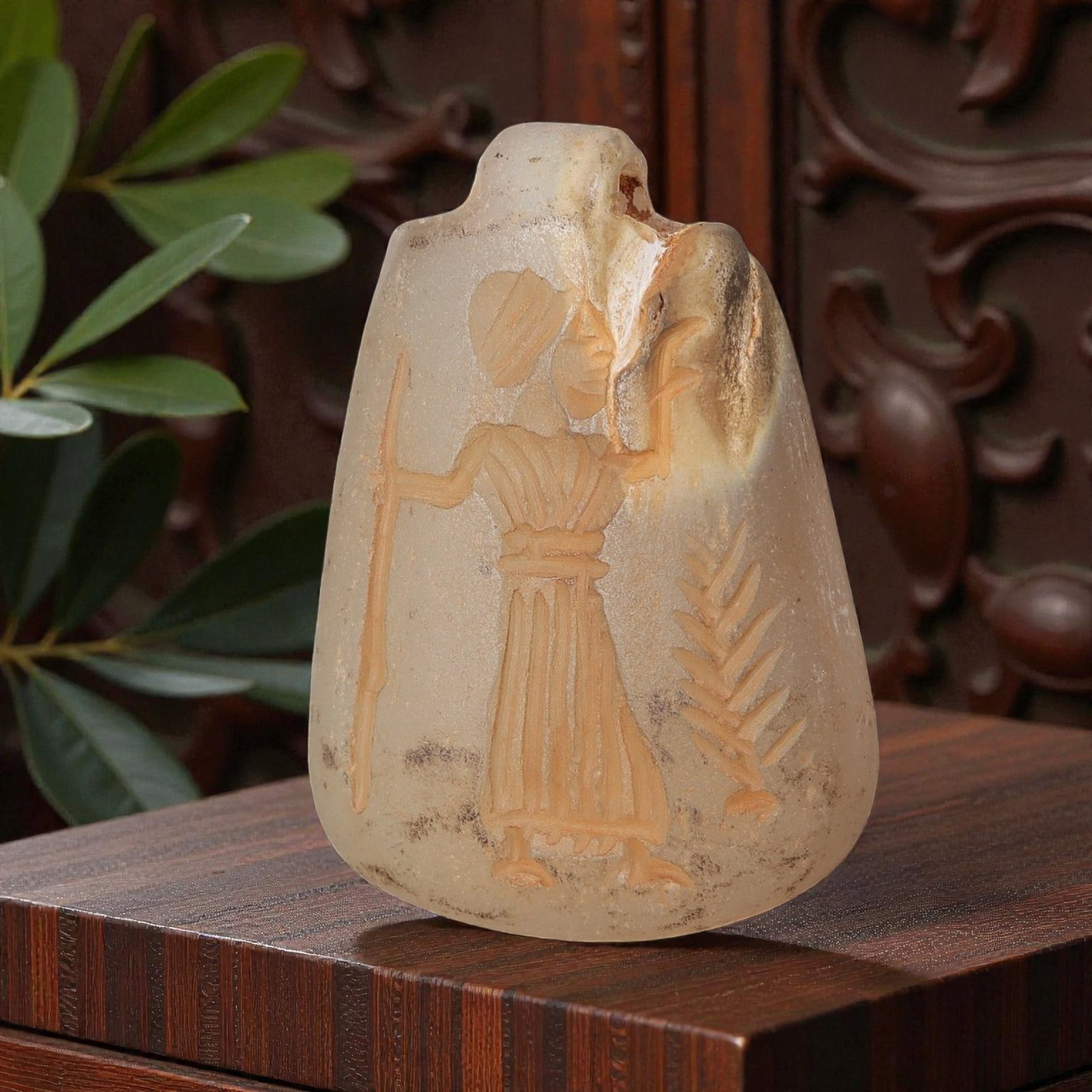 Ancient Sasanian Chalcedony Amulet Pendant, 58YD: This ancient amulet pendant is carved from translucent pale chalcedony, with a tapered shield-shaped form and suspension lug at the top. The face features a deeply engraved intaglio depicting a standi