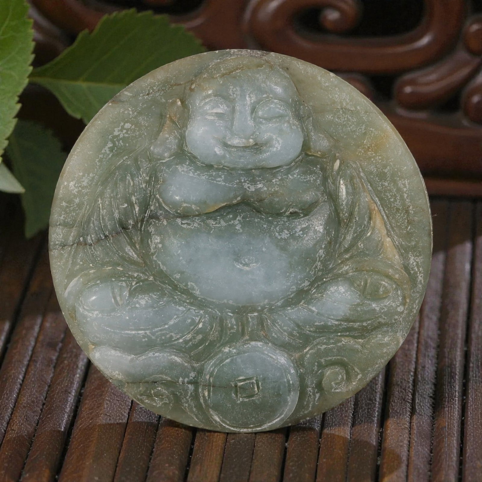 Old Chinese Jadeite Jade Budai Pendant, 9AP: Carved from jadeite jade with light green coloration and natural tonal variations, the pendant depicts Budai (the Laughing Buddha) in a seated pose. The figure has a rounded face with closed eyes and 