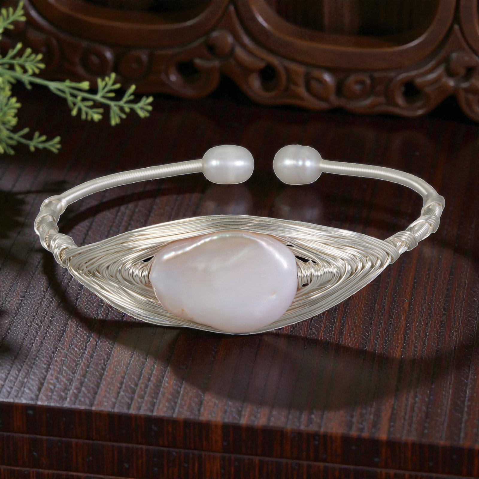 Natural Pinkish Baroque Pearl Silver Tone Wire-Woven Open Cuff Bracelet, 27EB: A handcrafted open cuff bracelet made with silver-toned wire, featuring an intricately woven, leaf-shaped wire frame that cradles a large natural pinkish baroque pearl at the center. The pearl exhibit