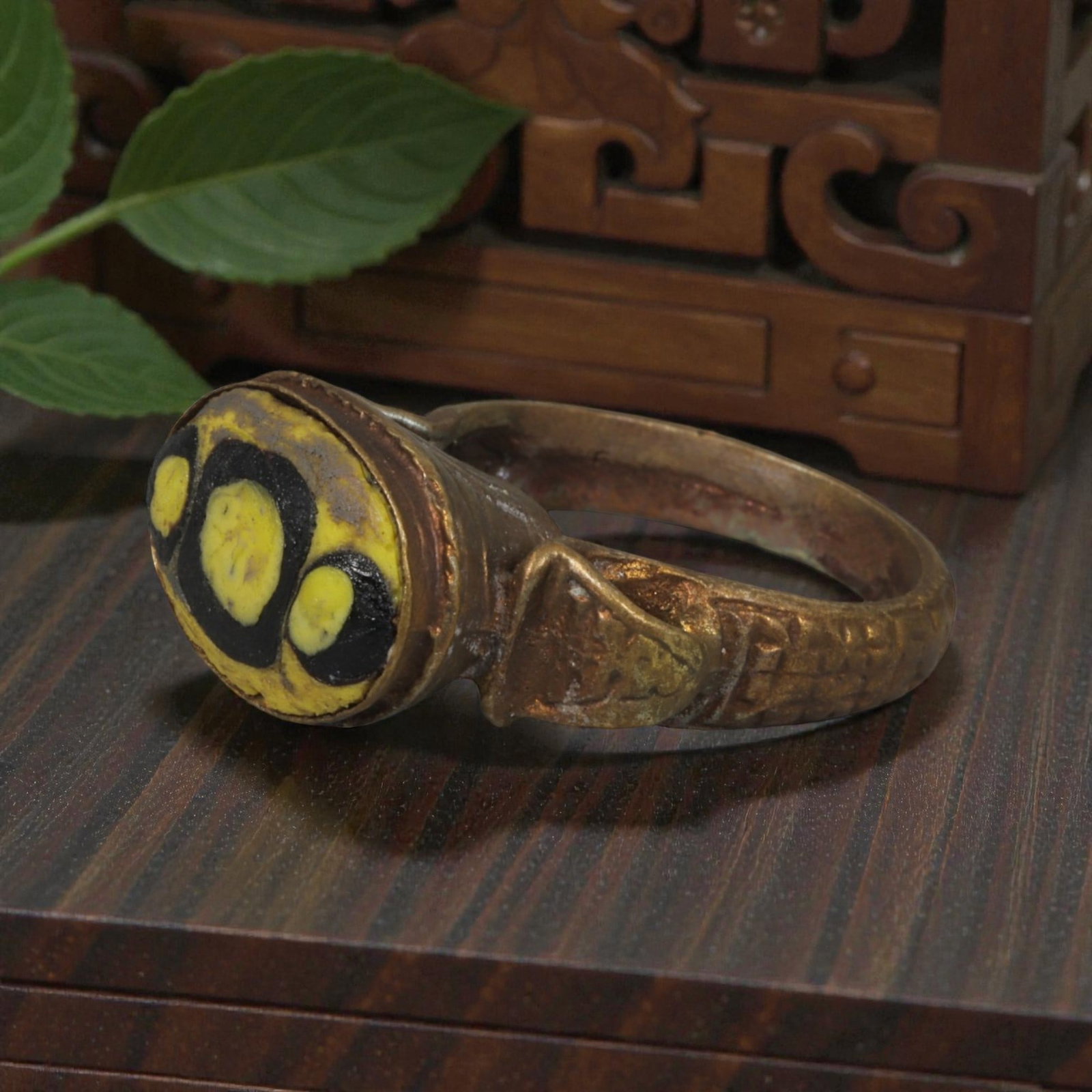 Antique Qajar Dynasty Gilt Evil Eye Ring, US Size 9, 8AJ: A gilt-metal ring of the Qajar period, US ring size 9, featuring an oval evil-eye glass inlay with a vibrant yellow and black multi-eye motif. The domed bezel is adorned with embossed geometric and fl