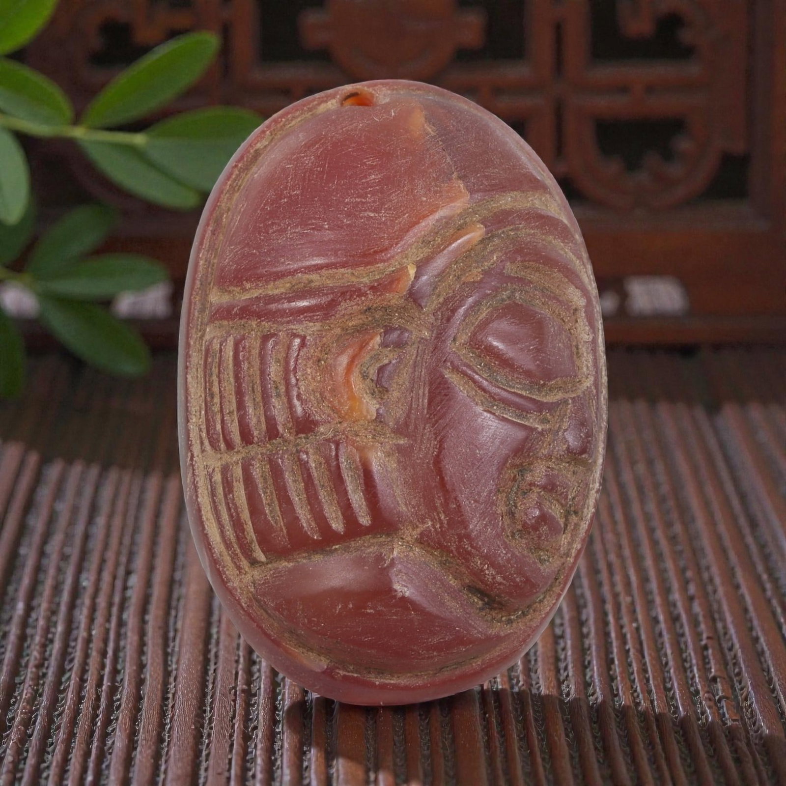 Antique Egyptian Carnelian Intaglio with Profile Head Motif, 99AN: Carved from carnelian with rich reddish-orange coloration, the oval-shaped intaglio features an incised profile head of a figure wearing a detailed headdress. The carving includes defined facial featu