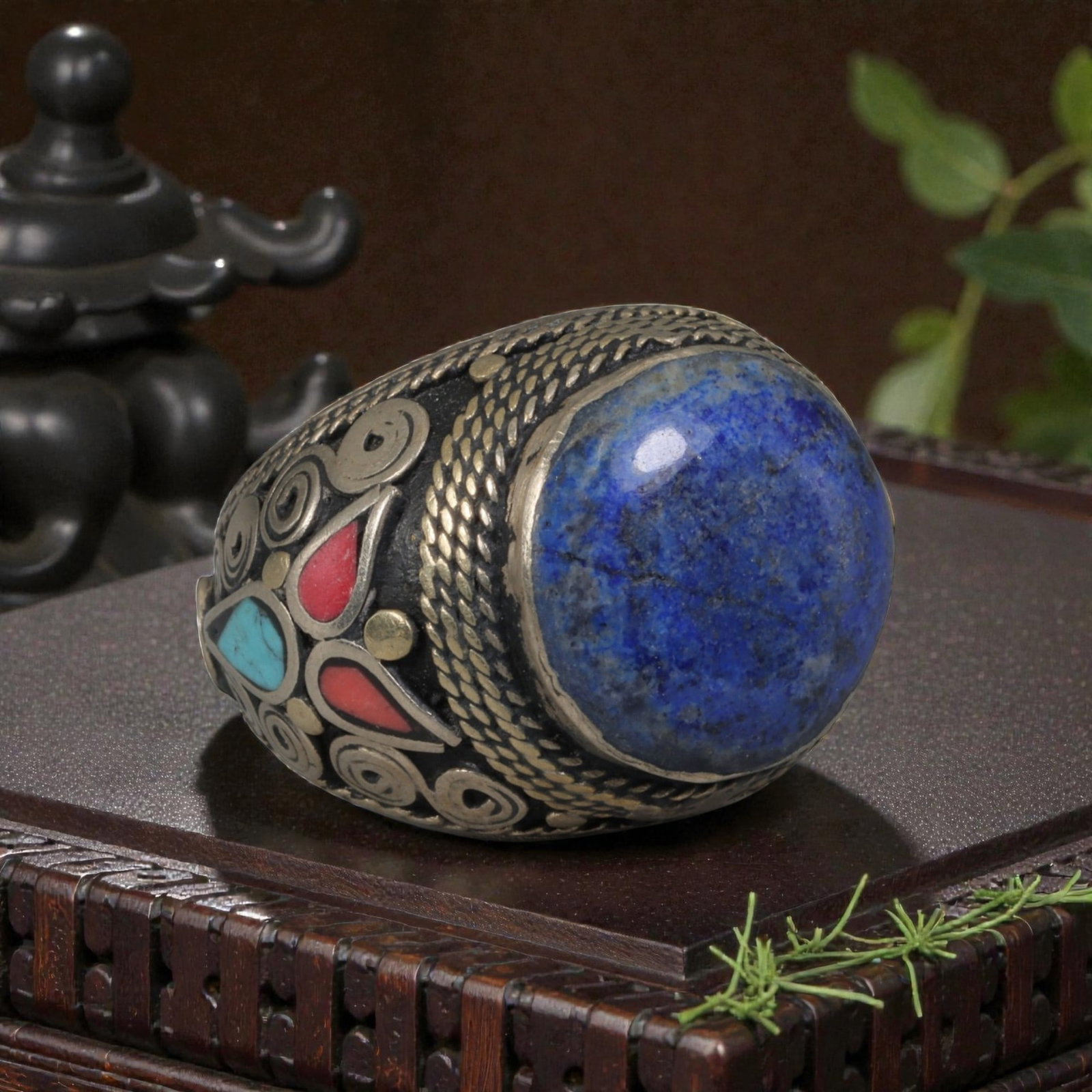 Antique Central Asian Silver and Lapis Lazuli Tribal Ring, 19th-Early 20th Century, 34AJ: The ring is set with a large, smooth cabochon lapis lazuli stone, displaying natural pyrite inclusions and surface cracks within its deep blue matrix. The silver mount is decorated with pseudo-filigre