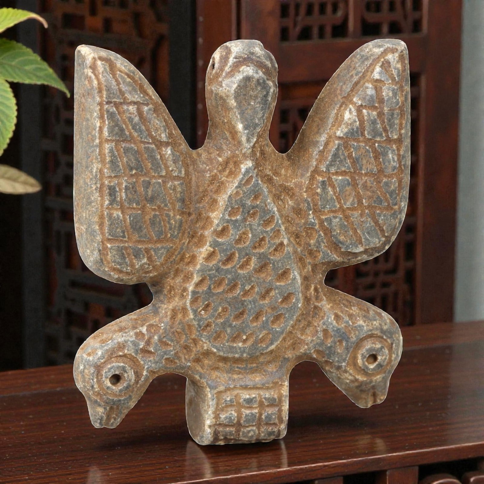 Ancient Stone Zoomorphic Amulet - Near Eastern Bird Figure, 21AM: This amulet is carved from dark stone, depicting a composite zoomorphic form with a central bird body, outstretched wings, and dual bird heads at the base, rendered in raised relief with incised geome