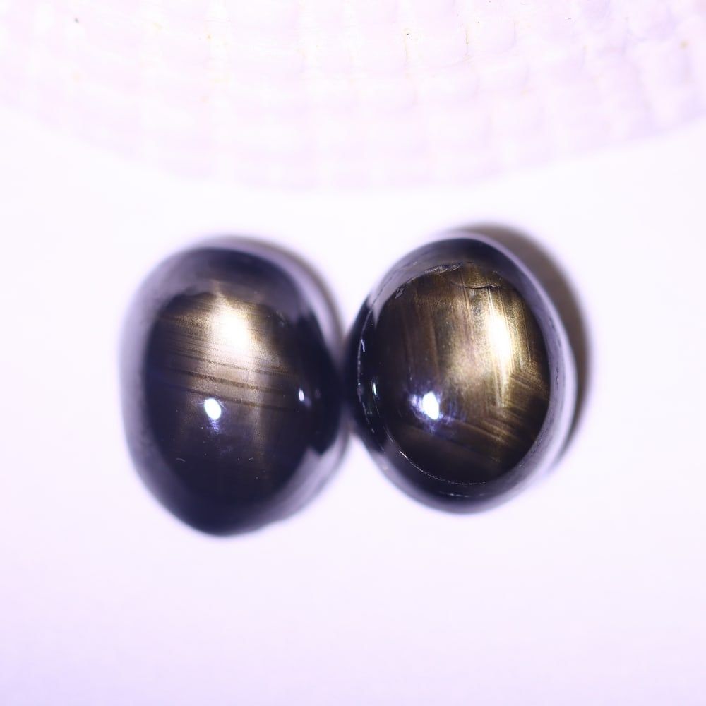 6.59cts 6 Rays Black Star Sapphire Pair , 768E: Ksmith Heritage Auctioneers Subject: Natural 6 Rays Star Sapphire Origin: Myanmar Carat Weight: 6.59cts Dimension: 8.6x6.5x4.9 mm Treatment: Diffusion Type: Cabochon, Poli