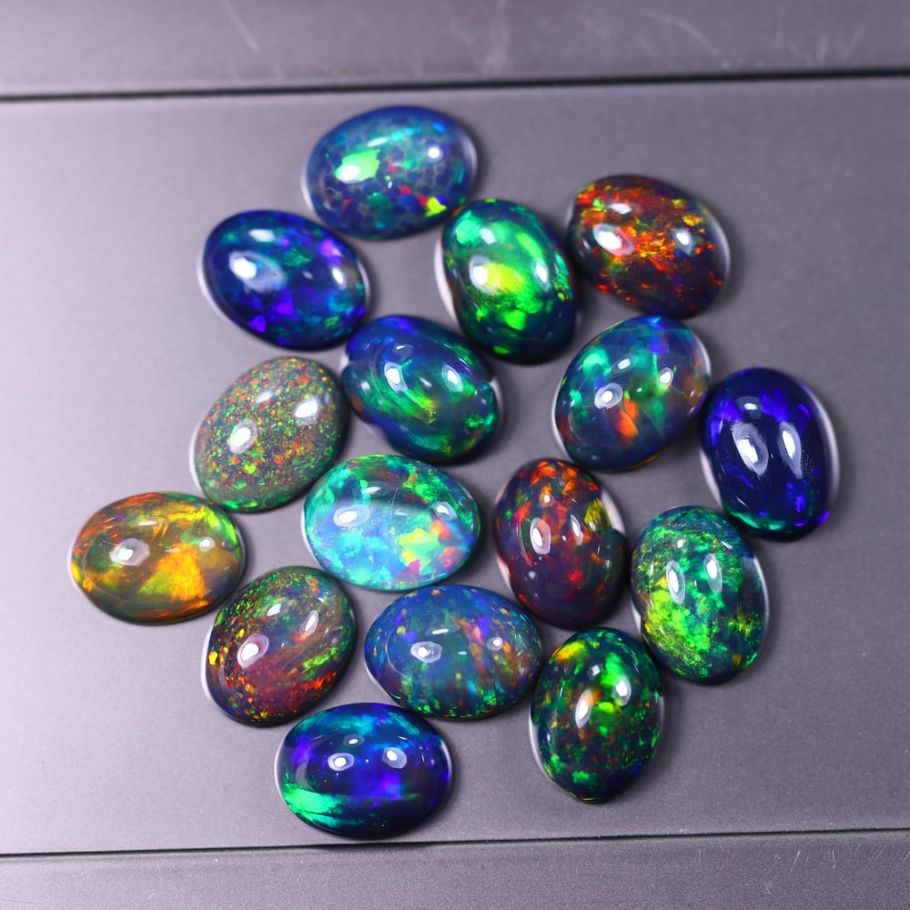 *13.04Ct 8x6mm Smoked Welo Opal Lot - Ethiopian Opal, 361C: Ksmith Heritage Auctioneers Subject: Natural Ethiopian Welo Opal Origin: Ethiopia Carat Weight: 13.04Ct Dimension: 7x6x3.4 mm Treatment: Smoked Type: Cabochon, Polished