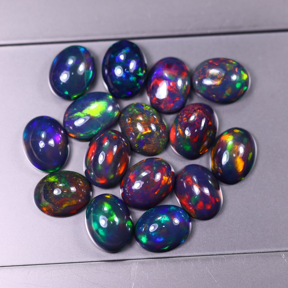 *18.56Ct 9x7mm Smoked Welo Opal Lot - Ethiopian Opal, 364C: Ksmith Heritage Auctioneers Subject: Natural Ethiopian Welo Opal Origin: Ethiopia Carat Weight: 18.56Ct Dimension: 9x7x4.5 mm Treatment: Smoked Type: Cabochon, Polished