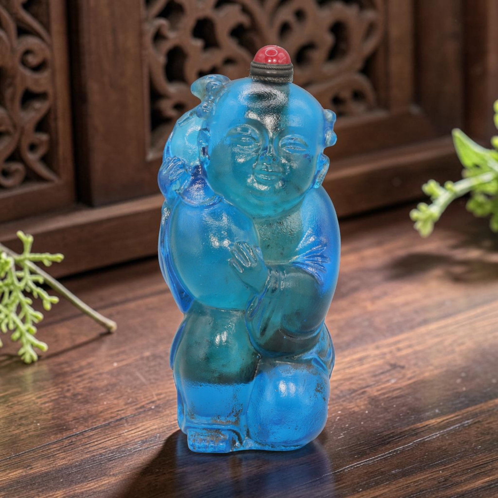 Vintage Chinese Blue Liuli Glass Snuff Bottle - Child Figurine, 82YF: Crafted from vibrant blue liuli glass, this vintage Chinese snuff bottle is modelled as a stylized child figure holding a gourd. The glass exhibits a translucent, rich blue hue with subtle inclusions 